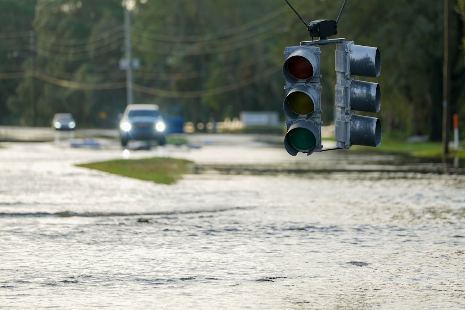 A traffic light hangs low as flood waters cover a road the morning after Hurricane Milton hit the region, Thursday, Oct. 10, 2024, in Tampa, Fla. (AP Photo/Julio Cortez)