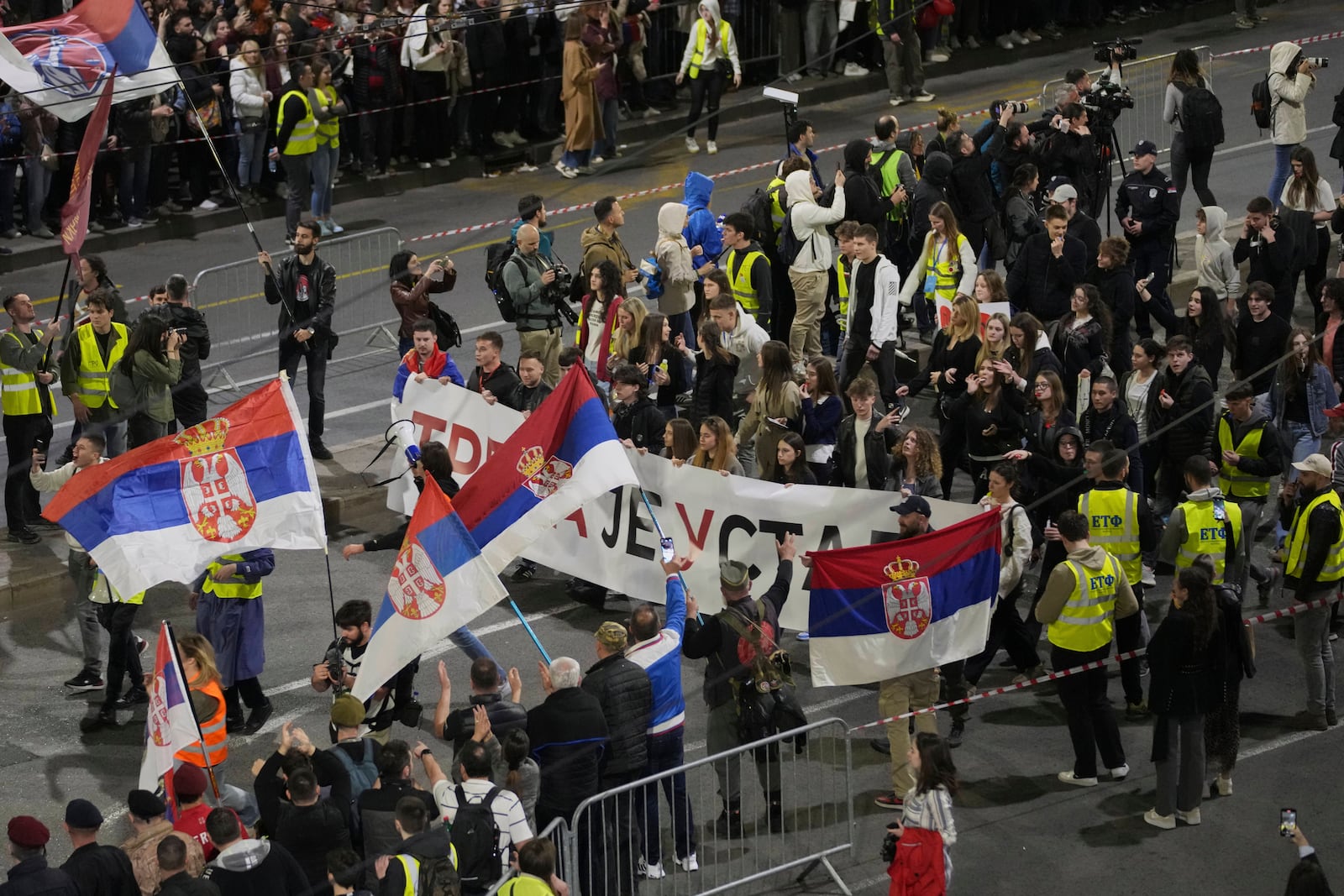 Protesters waving flags march ahead of a major rally this weekend in downtown Belgrade, Serbia, Friday, March 14, 2025. (AP Photo/Darko Vojinovic)