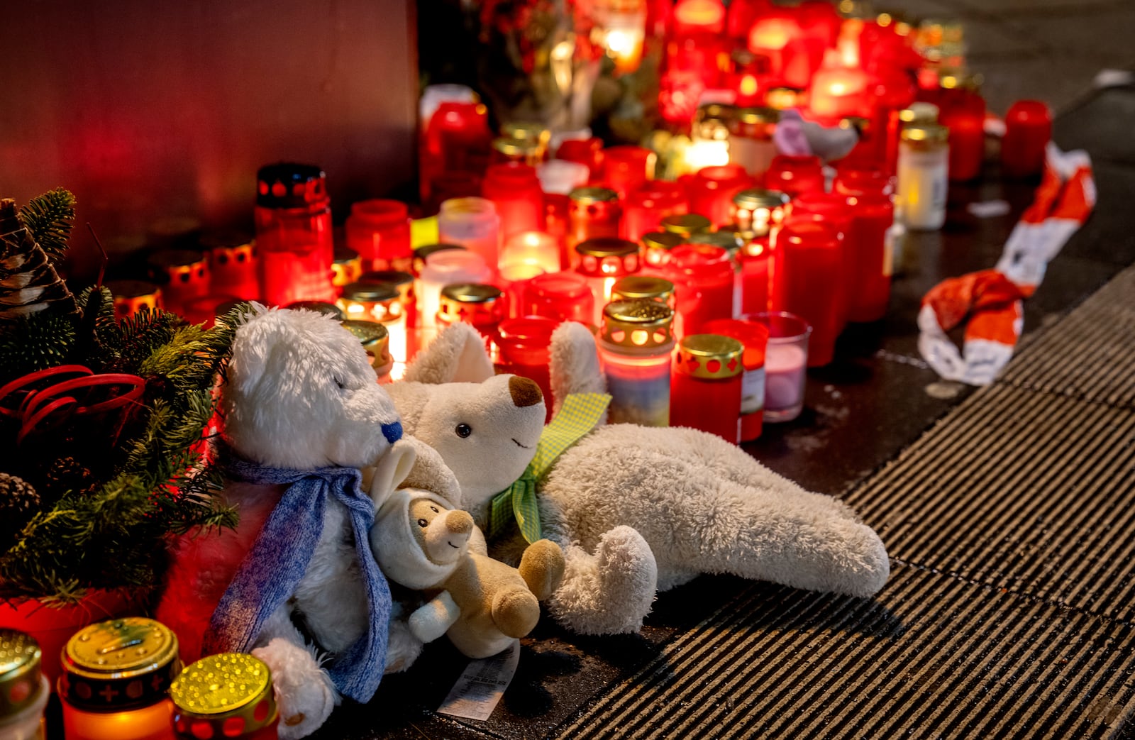 Teddy bears were laid together with candles near the Christmas market, where a car drove into a crowd on Friday evening, in Magdeburg, Germany, Sunday, Dec. 22, 2024. (AP Photo/Michael Probst)