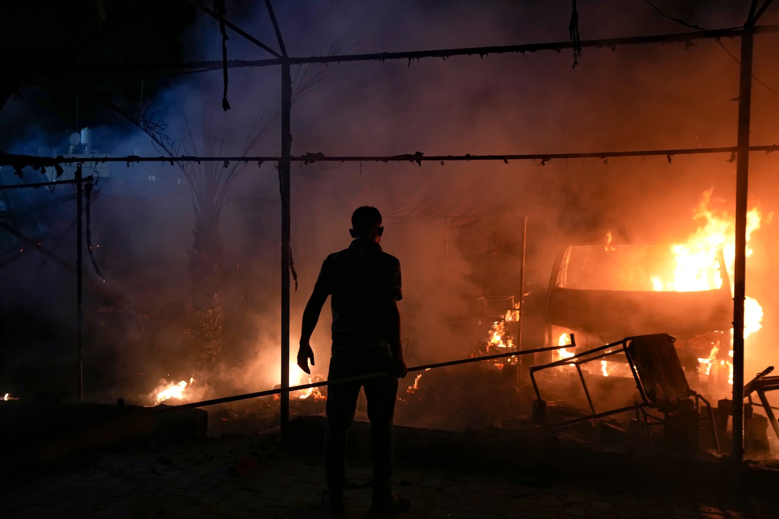 A Palestinian man reacts to a fire after an Israeli strike hit a tent area in the courtyard of Al Aqsa Martyrs hospital in Deir al Balah, Gaza Strip, Monday, Oct. 14, 2024. (AP Photo/Abdel Kareem Hana)