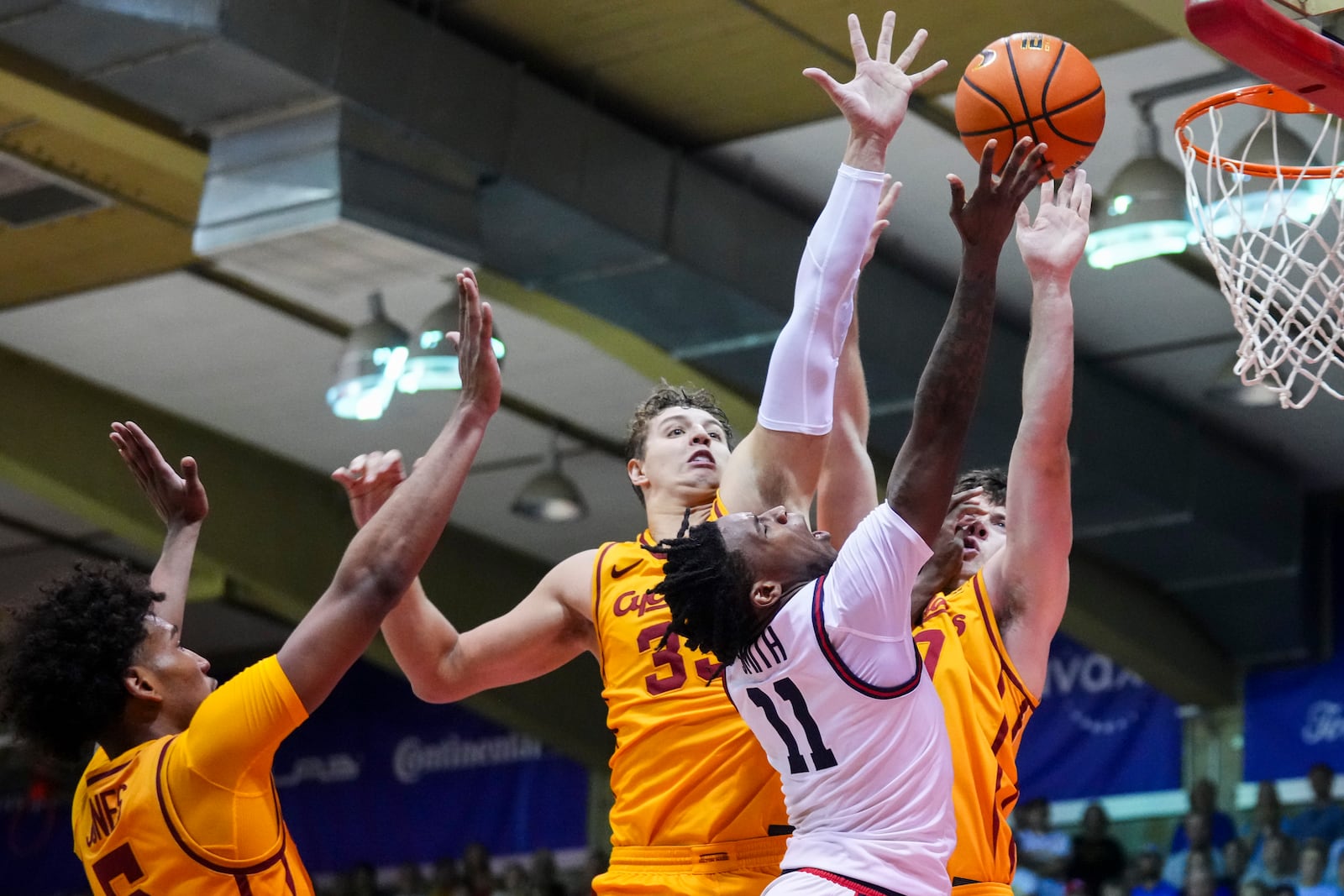 Dayton guard Malachi Smith (11) goes to the basket against Iowa State guard Curtis Jones, left, forward Brandton Chatfield, center, and guard Nate Heise, back right, during the second half of an NCAA college basketball game at the Maui Invitational Tuesday, Nov. 26, 2024, in Lahaina, Hawaii. Iowa State won 89-84. (AP Photo/Lindsey Wasson)