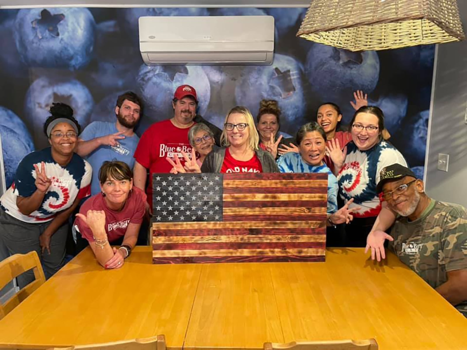 Kelly Andary (front row right of center in blue tie die shirt) and her staff at the Blue Berry Cafe in Bellbrook have weathered the past two years by focusing on giving back to the community, including offering free hot meals for kids during the shutdown and beyond, turning their lobby into a food pantry, and making almost everything on their menu available for carryout.