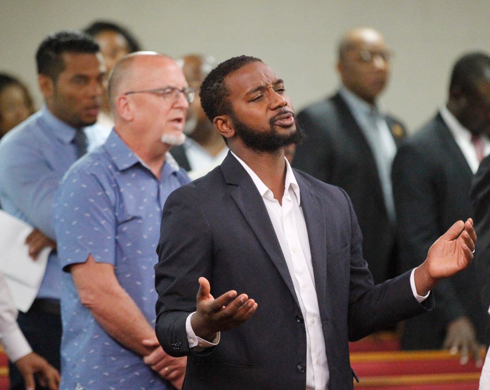 Israel Baxter, Pastor, New Hope Life Chruch, during a prayer vigil hosted by The Tabernacle Baptist Church on Thursday in Dayton. Declare Dayton: A City-Wide Hour of Prayer featured local pastors who took turns praying and singing with participants for healing in the wake of the mass shooting and tornadoes.   TY GREENLEES / STAFF