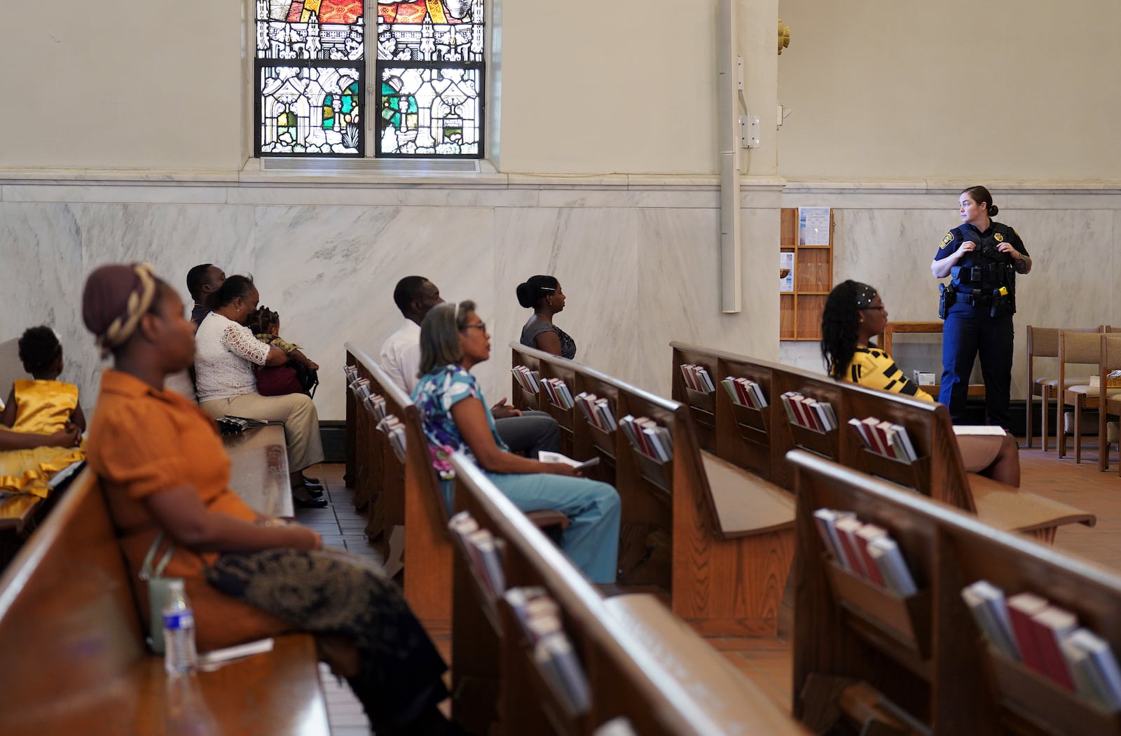 A Springfield police officer stands watch during a service in support of the Haitian community at St. Raphael Catholic church in Springfield, Ohio, Sunday, Sept. 15, 2024. (AP Photo/Jessie Wardarski)