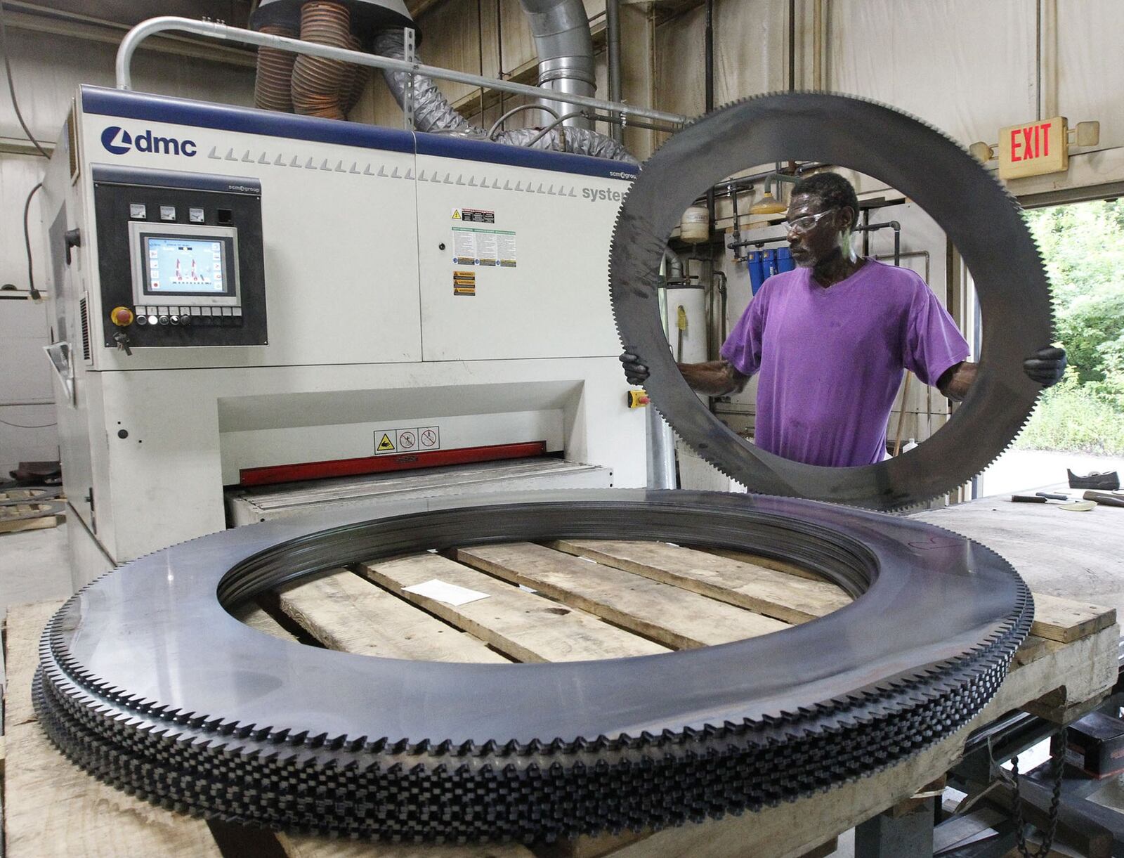 Thearon Moore operates a deburring machine at Staub Manufacturing Solutions. Co-owner Steve Staub says the company pays $15 an hour and offers full benefits for entry-level metal grinding jobs but has had trouble finding workers. TY GREENLEES / STAFF