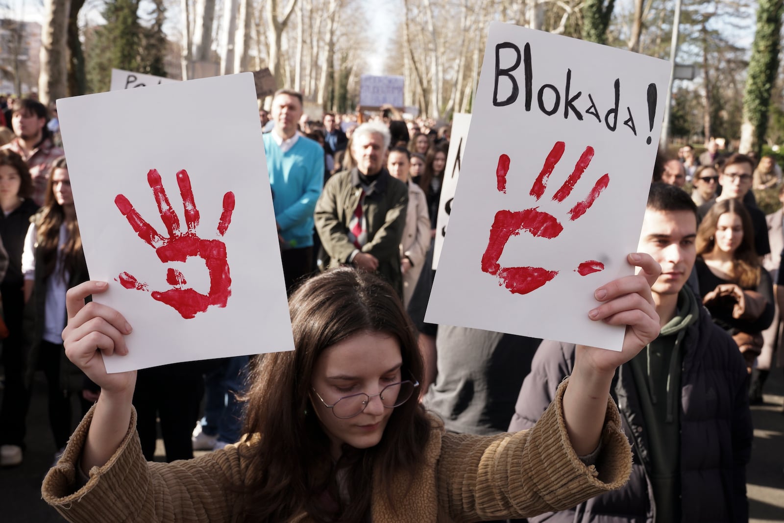 A young woman holds banners during a protest to support Serbian students, in the Bosnian town of Banja Luka, 240 kms northwest of Sarajevo, Friday, Jan. 31, 2025. Banner reads: "Blockade!". (AP Photo/Radivoje Pavicic)