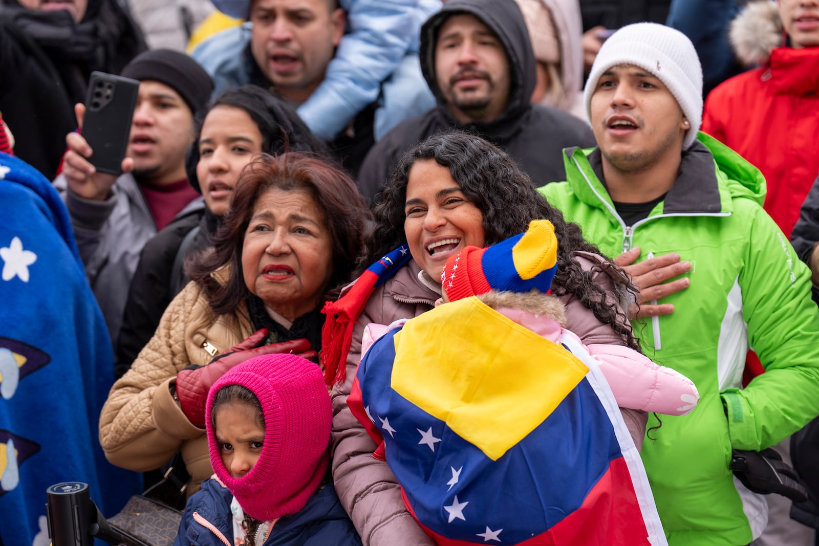 Carolina di Martino Popovich, center, holds her daughter Isabella, 1, next to her mother Petra Gambor, and other daughter Camila, 6, as they sing along with Venezuelan opposition leader Edmundo Gonzalez, outside of the Organization of American States, Monday, Jan. 6, 2025, in Washington. "We drove 10 hours in the snowstorm from Boston and we made it," said di Martino Popovich, "that is how much he means to us. We couldn't vote in Venezuela but we are here to recognize him as our President." The mother and daughter are long time immigrants from Venezuela who live in Boston. (AP Photo/Jacquelyn Martin)