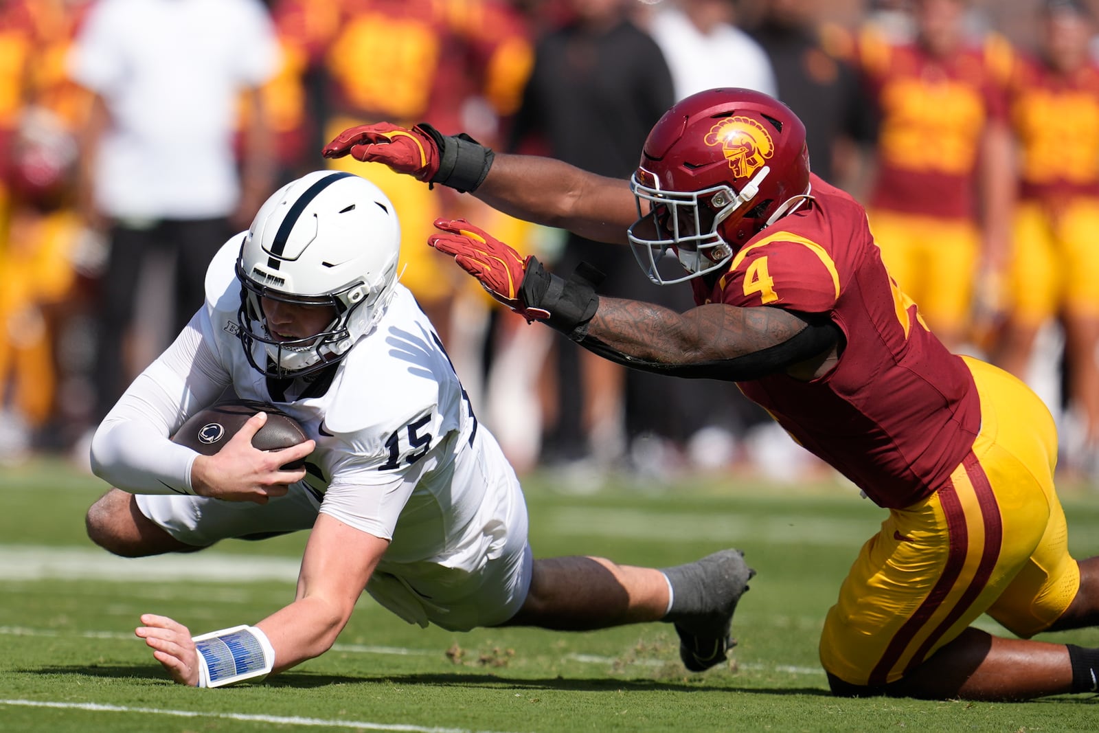 Penn State quarterback Drew Allar (15) lunges past Southern California linebacker Easton Mascarenas-Arnold (4) during the first half of an NCAA college football game Saturday, Oct. 12, 2024, in Los Angeles. (AP Photo/Marcio Jose Sanchez)