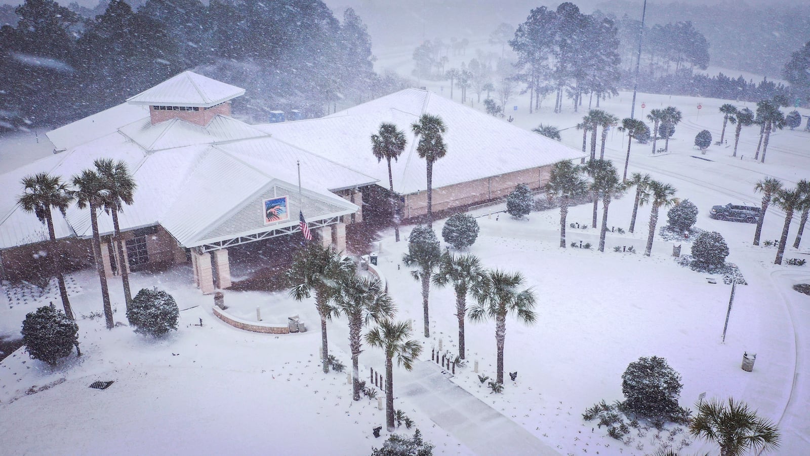 Heavy snow falls onto the Florida Welcome Center on Tuesday, Jan. 21, 2025 in Pensacola, Fla. (Luis Santana/Tampa Bay Times via AP)