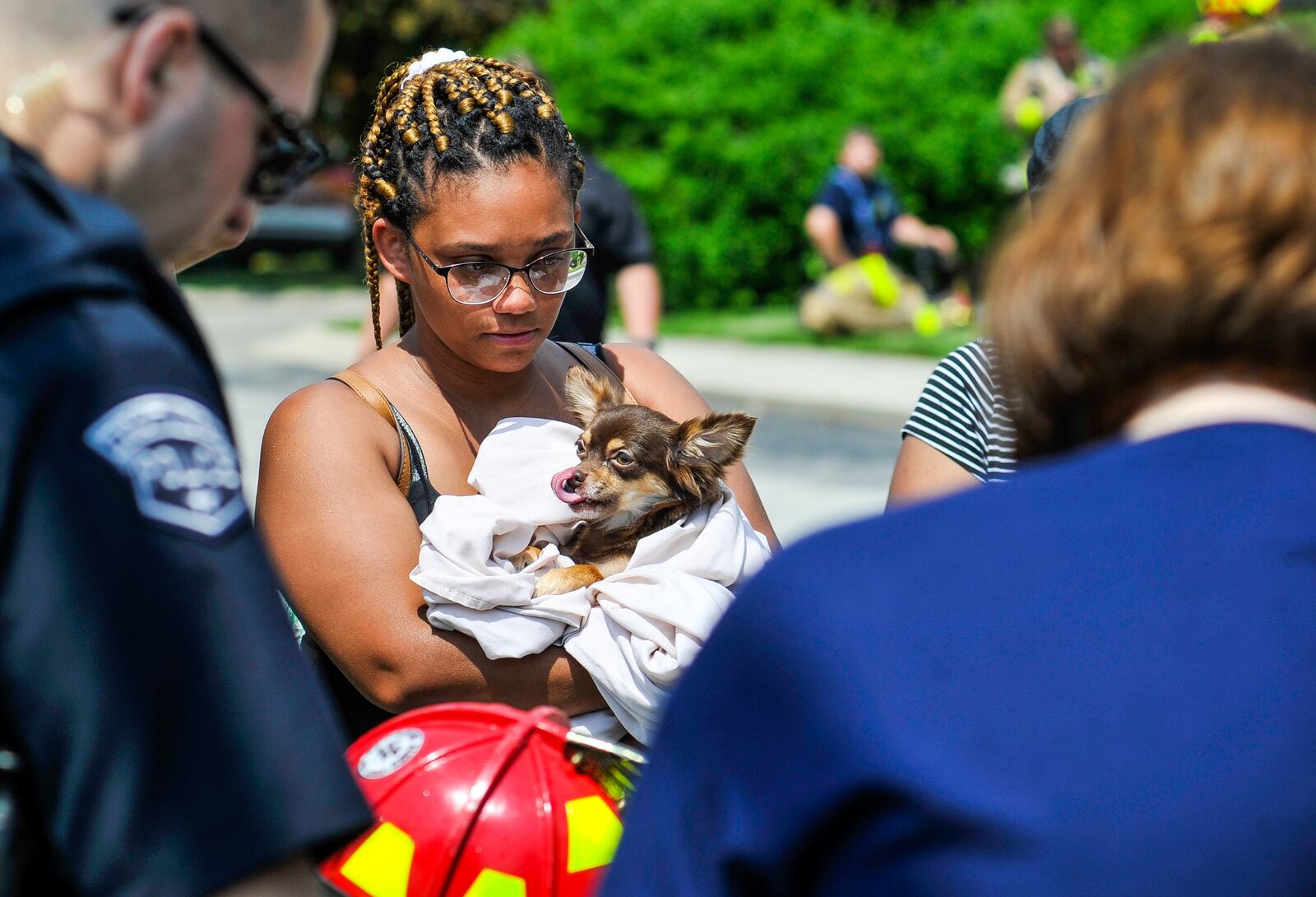 Whitney Waldon holds her long-haired chihuahua as police and fire crews give oxygen to another one of her dogs.