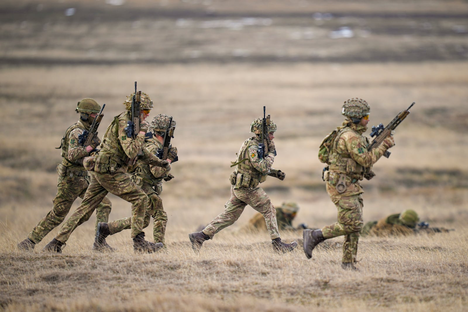 Servicemen run during the Steadfast Dart 2025 exercise, involving some 10,000 troops in three different countries from nine nations and represent the largest NATO operation planned this year, at a training range in Smardan, eastern Romania, Wednesday, Feb. 19, 2025. (AP Photo/Vadim Ghirda)