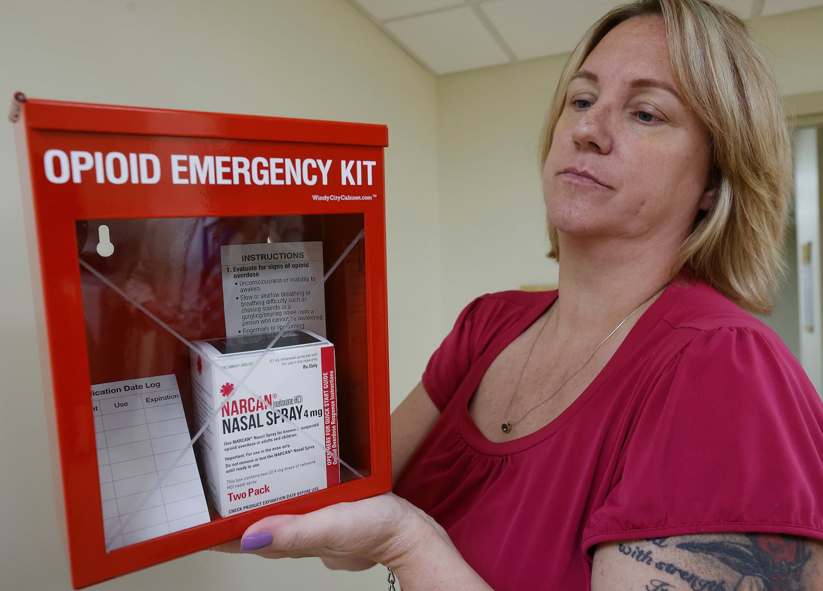 Dawn Schwartz, project manager for the Community Overdose Action Team, holds up Opioid Emergency kits that the Public Health -- Dayton & Montgomery County will offer businesses and employers. Public Health also will provide free training to teach workers how to administer the medication. MARSHALL GORBY\STAFF