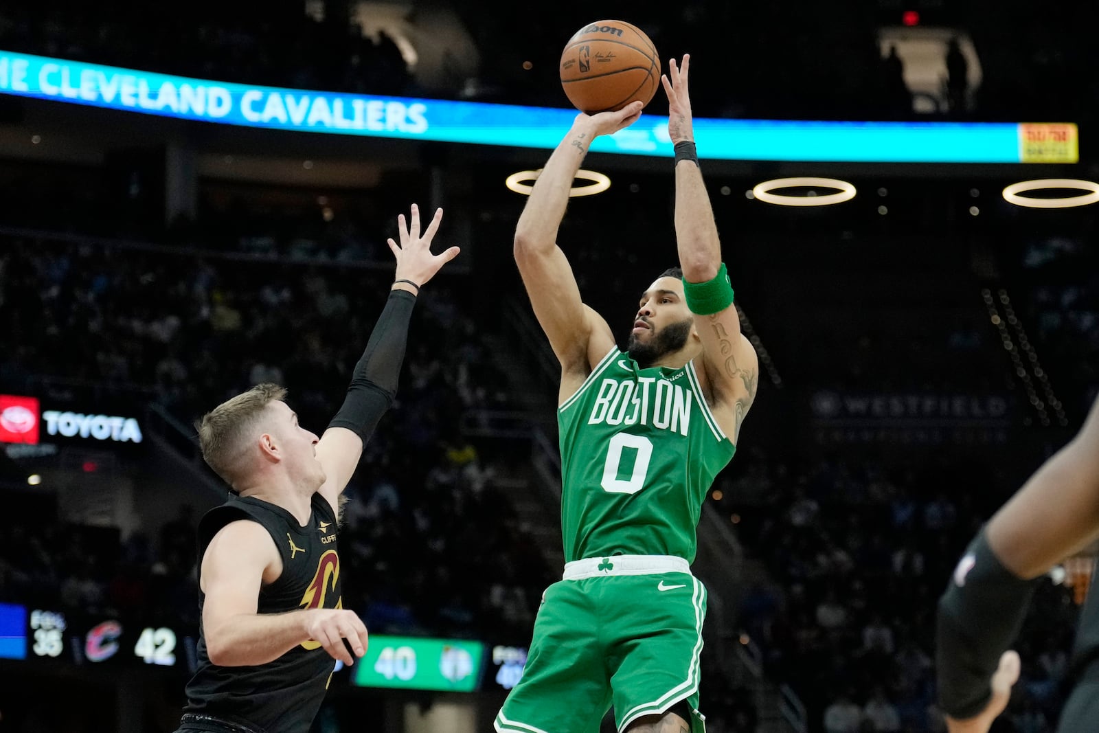 Boston Celtics forward Jayson Tatum (0) shoots over Cleveland Cavaliers guard Sam Merrill, left, in the second half of an NBA basketball game, Tuesday, Feb. 4, 2025, in Cleveland. (AP Photo/Sue Ogrocki)