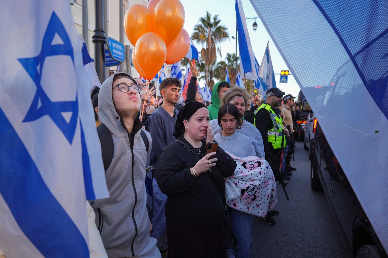 Mourners react as the convoy carrying the coffins of slain hostages Shiri Bibas and her two children, Ariel and Kfir, passes by during their funeral procession in Rishon Lezion, Israel, Wednesday, Feb. 26, 2025. The mother and her two children were abducted by Hamas on Oct. 7, 2023, and their remains were returned from Gaza to Israel last week as part of a ceasefire agreement with Hamas. (AP Photo/Ariel Schalit)