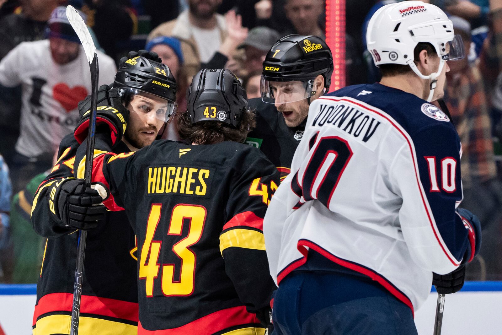 Vancouver Canucks' Pius Suter (24) celebrates his goal with Quinn Hughes (43) and Carson Soucy (7) during the third period of an NHL hockey game against the Columbus Blue Jackets in Vancouver, British Columbia, Friday, Dec. 6, 2024. (Ethan Cairns/The Canadian Press via AP)