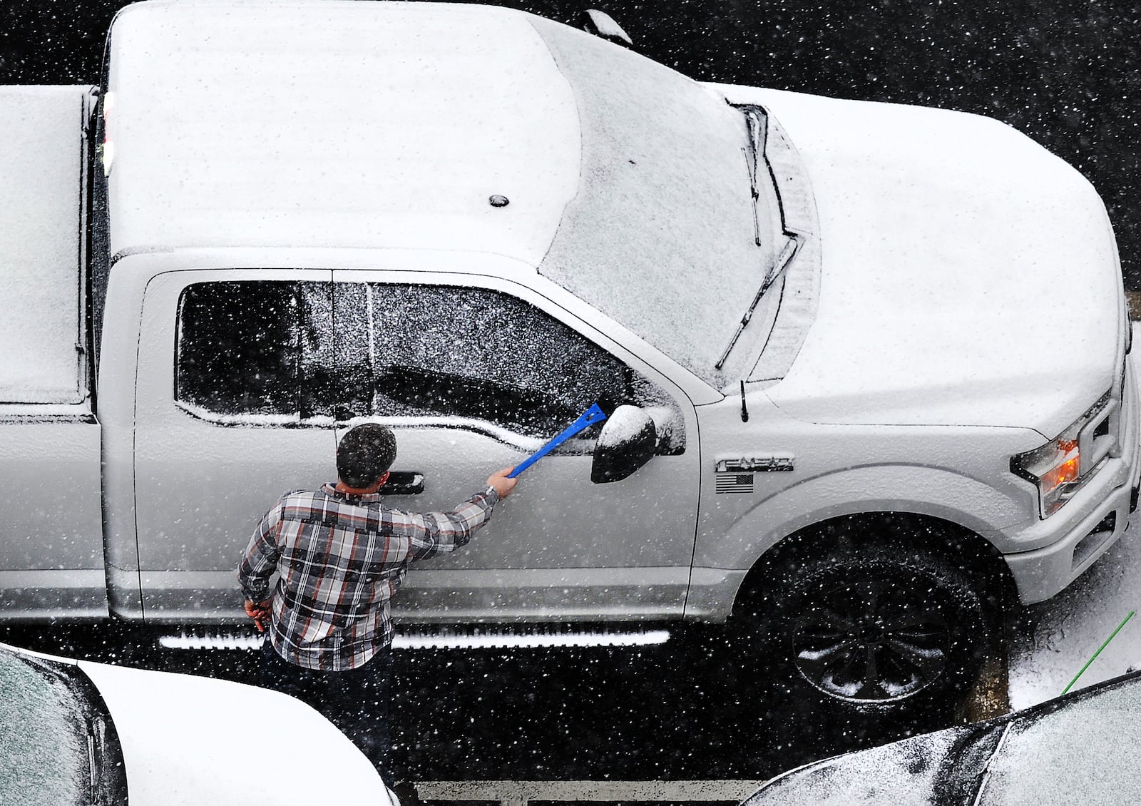 Workers have to remove snow from their cars Friday, Feb. 16, 2024 before going home.  MARSHALL GORBY\STAFF