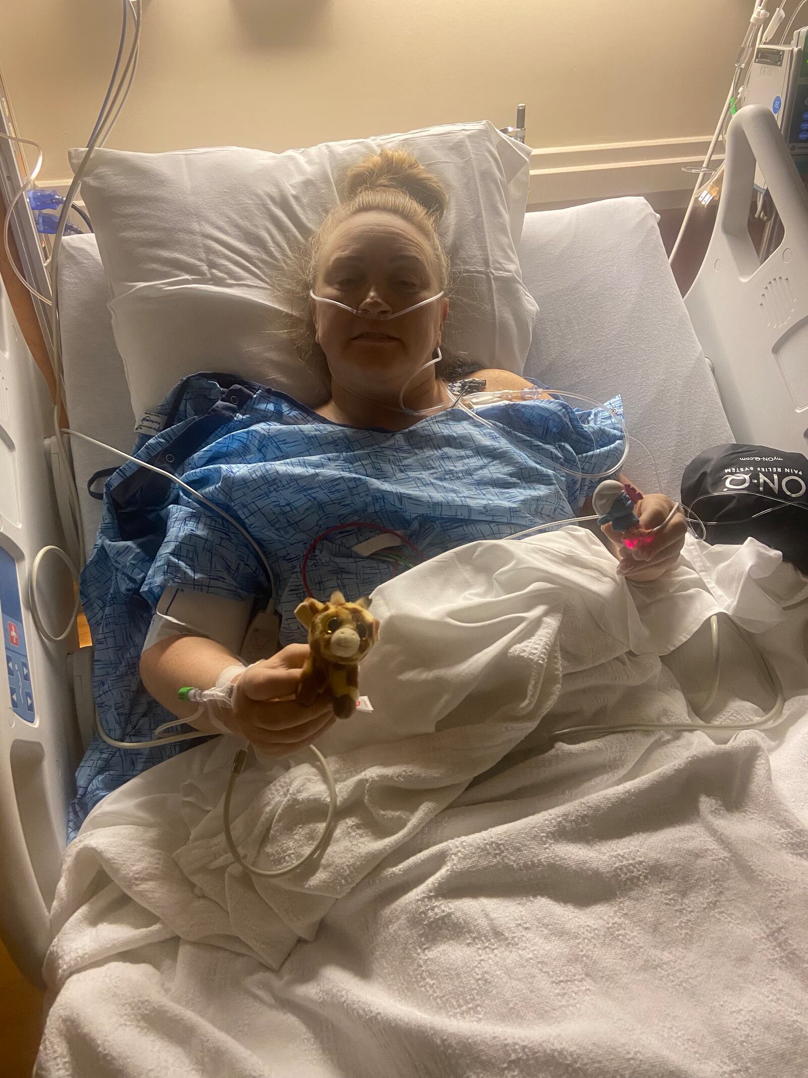 Melissa LaPeer in recovery after her double mastectomy on March 7. In her left hand she holds a character from "The Smurfs" - a good luck charm she always sent to her students when they were injured and facing surgery. CONTRIBUTED