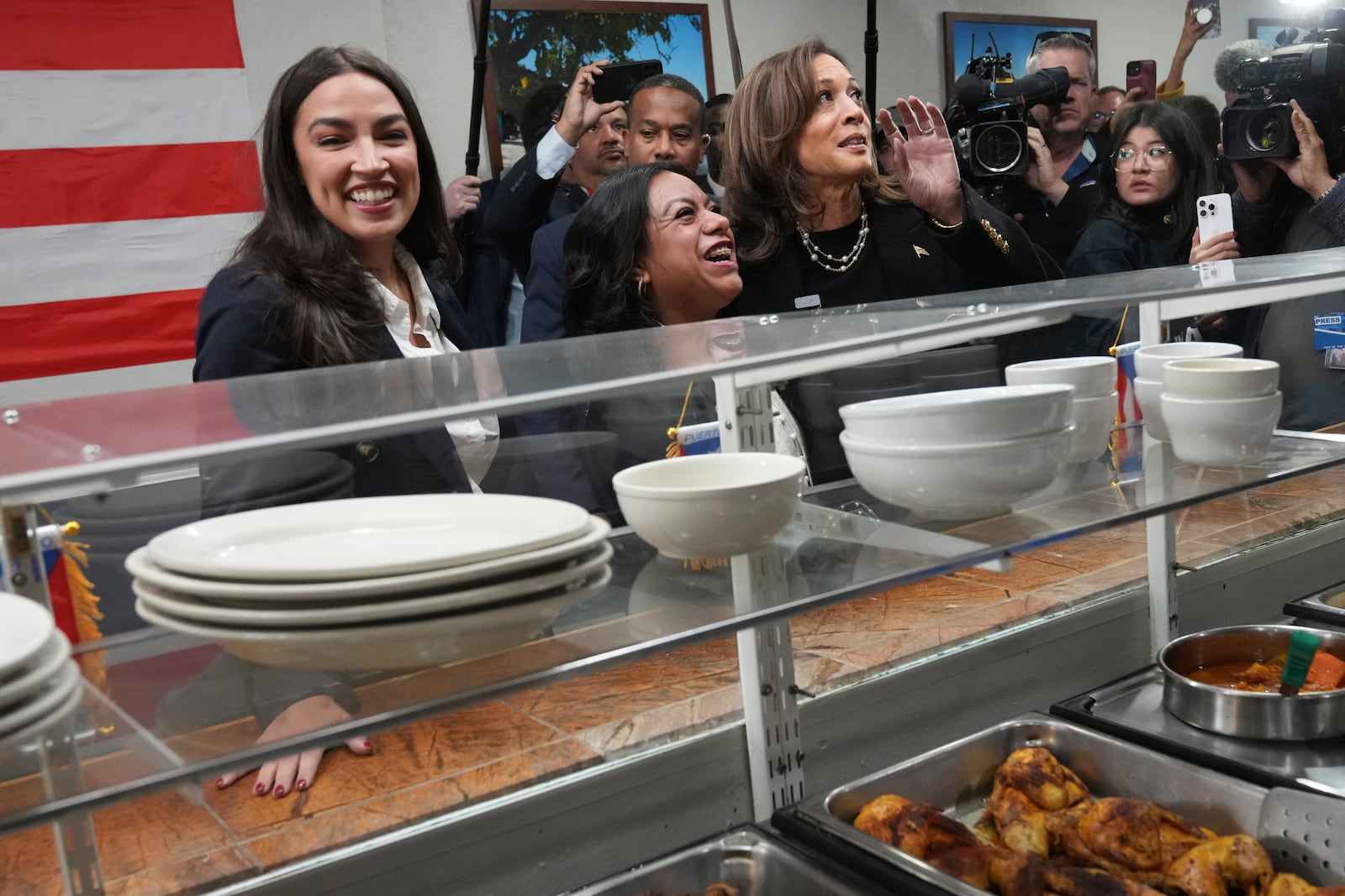 Democratic presidential nominee Vice President Kamala Harris, from right, visits Old San Juan Cafe restaurant with restaurant owner Diana de La Rosa and Rep. Alexandria Ocasio-Cortez, D-N.Y., during a campaign stop in Reading, Pa., Monday, Nov. 4, 2024. (AP Photo/Jacquelyn Martin)