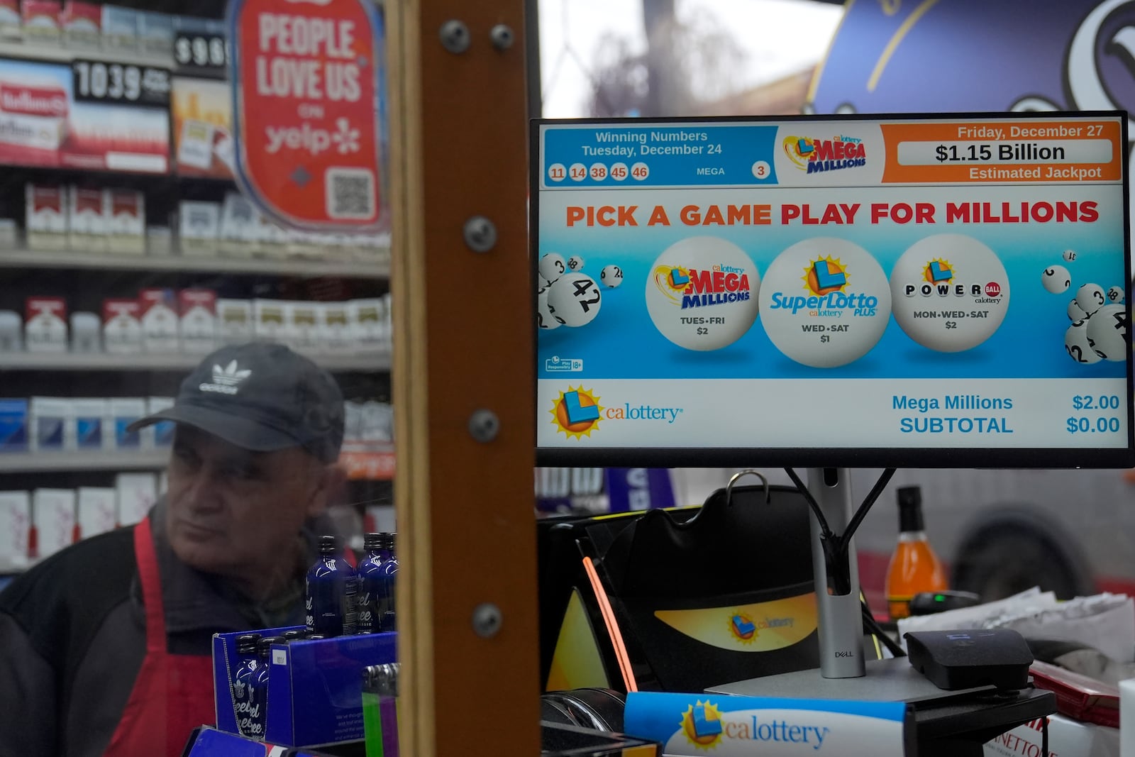 Oscar Flores, left, works behind the counter next to a sign advertising the estimated $1.15 billion Mega Millions jackpot at Rossi's Deli in San Francisco, Thursday, Dec. 26, 2024. (AP Photo/Jeff Chiu)