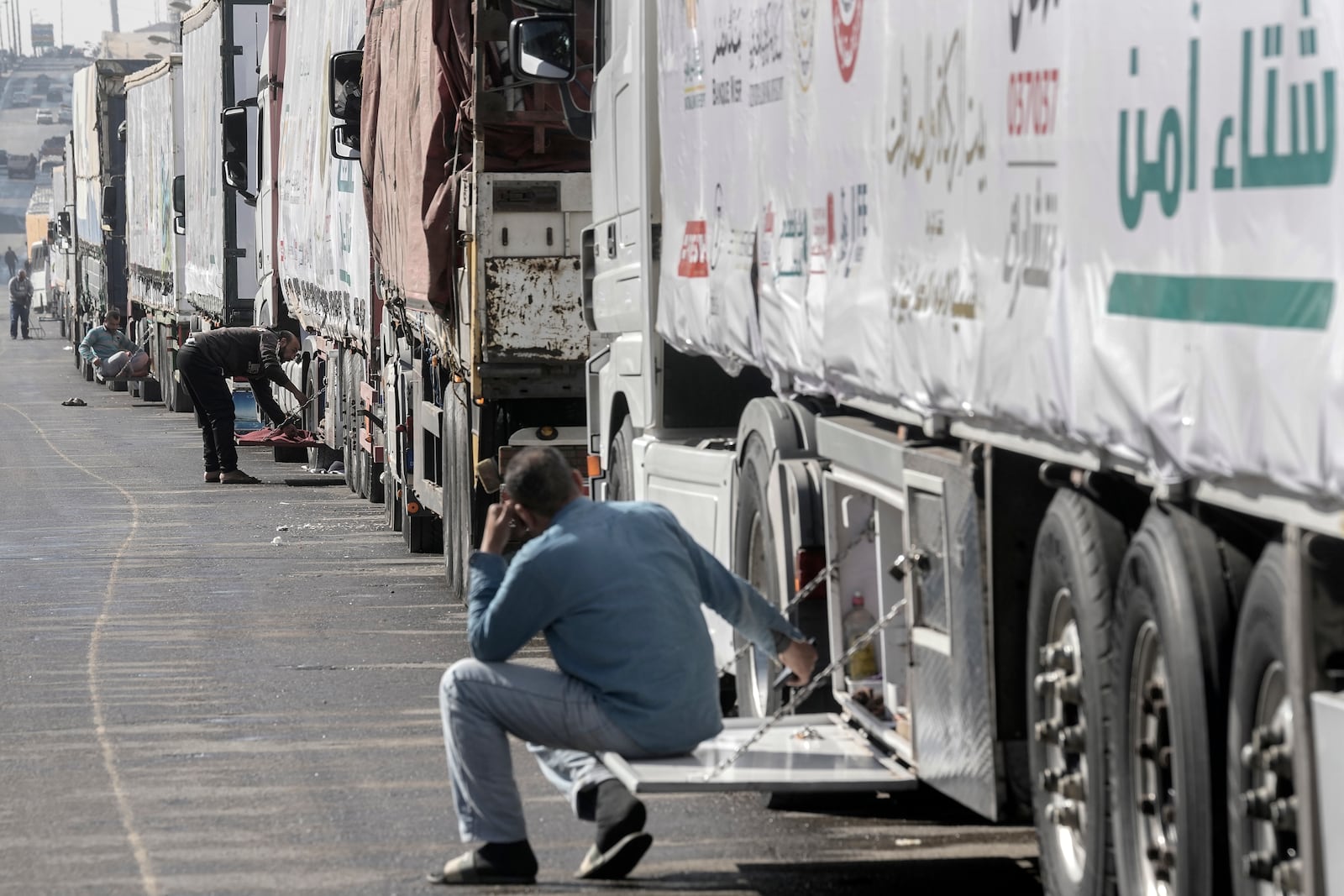 Truck drivers of humanitarian aid wait at a parking point in Cairo, Egypt, on their way to cross the Rafah border crossing between Egypt and the Gaza Strip, Sunday, Jan. 26, 2025. (AP Photo/Amr Nabil)