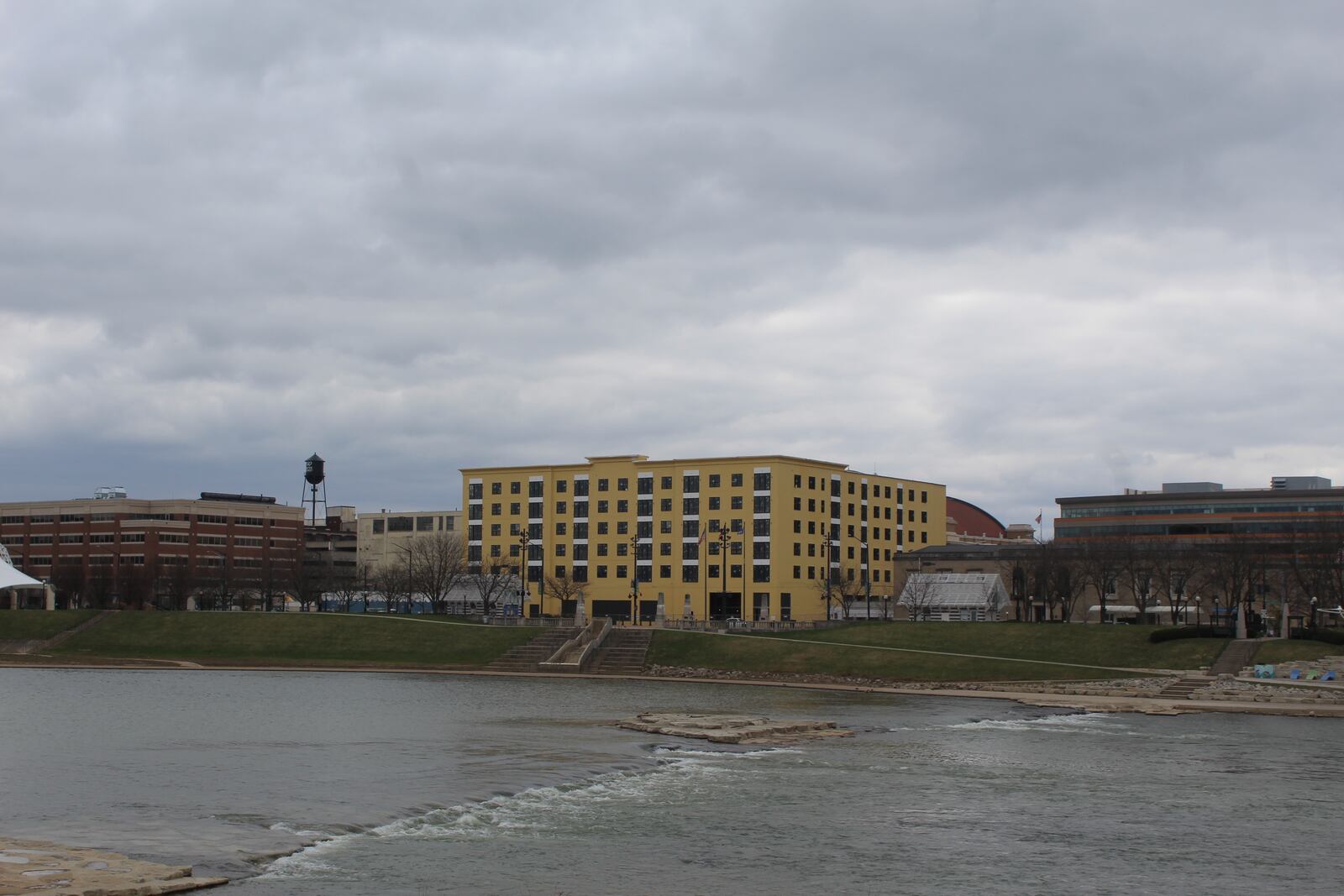 Work continues on the Monument apartments, the building in yellow across from RiverScape MetroPark in downtown Dayton. CORNELIUS FROLIK / STAFF