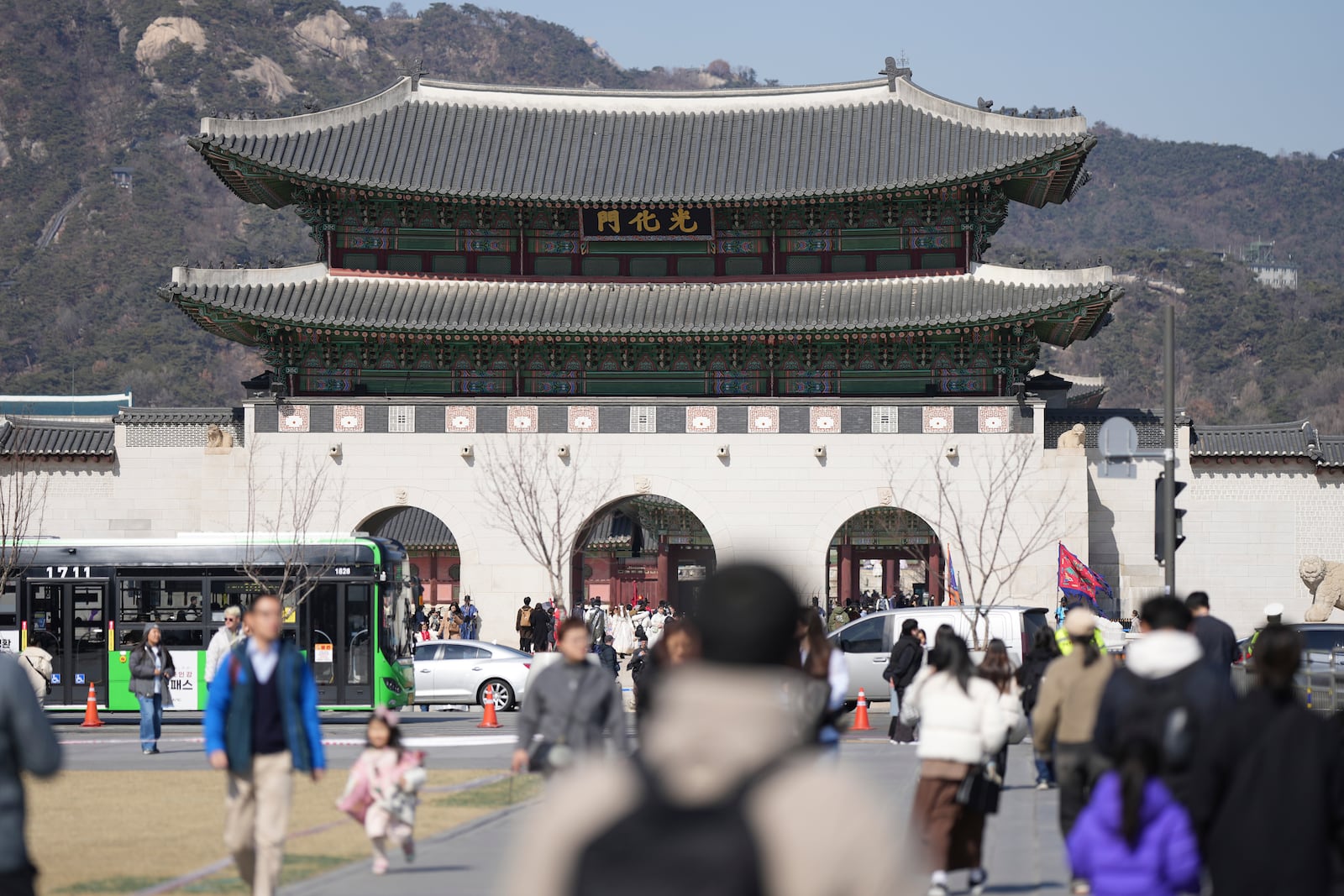 Visitors walk near the Gwanghwamun, the main gate of the 14th-century Gyeongbok Palace, one of South Korea's well known landmarks, in Seoul, South Korea, Thursday, Feb. 27, 2025. (AP Photo/Lee Jin-man)