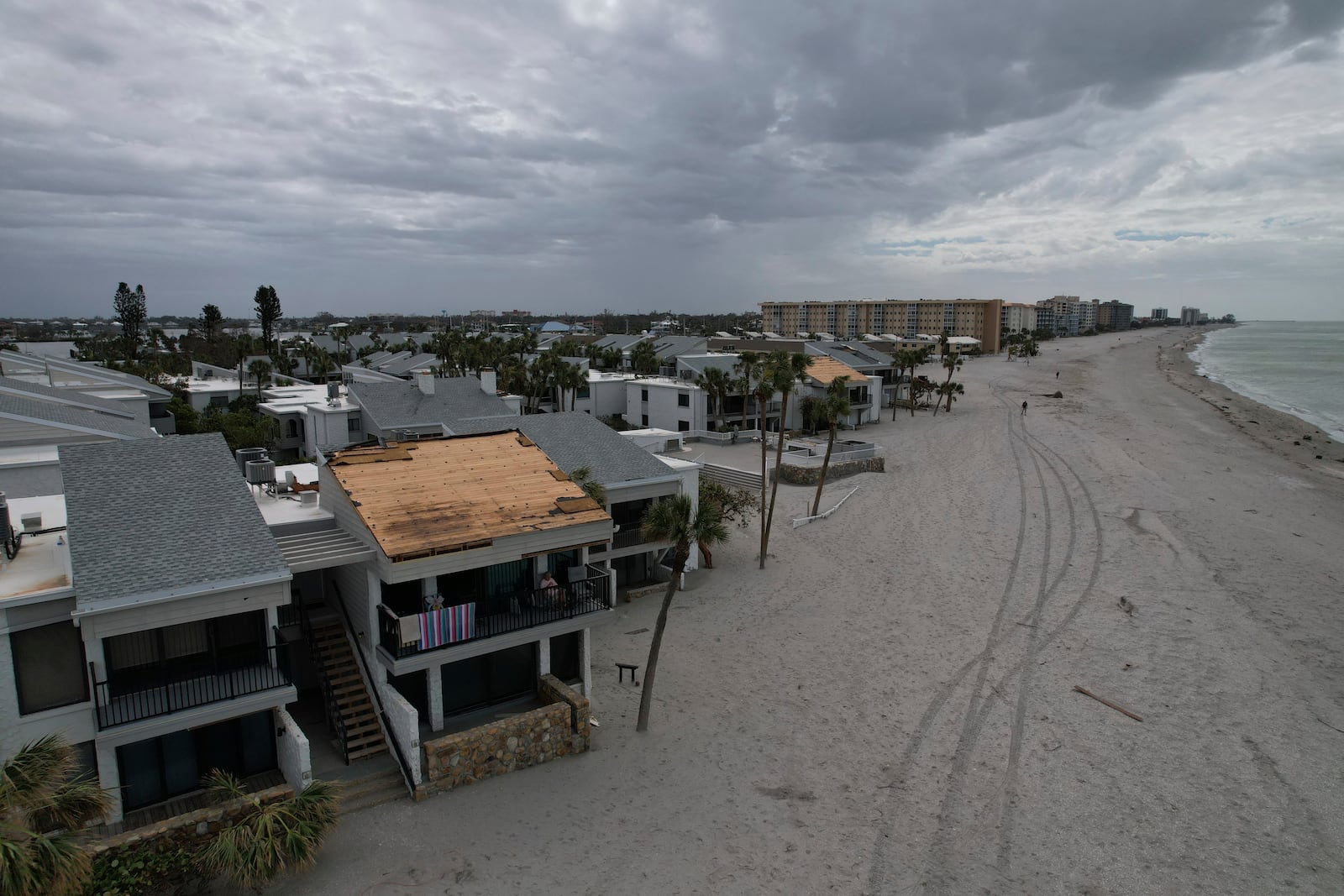 Ron Dyer, who has lived full-time at Bahia Vista Gulf with his wife Jean since 2019, sits on the balcony of their beachfront condo, which lost part of its roof in the passage of Hurricane Milton, on the island of Venice, Fla., Friday, Oct. 11, 2024. (AP Photo/Rebecca Blackwell)