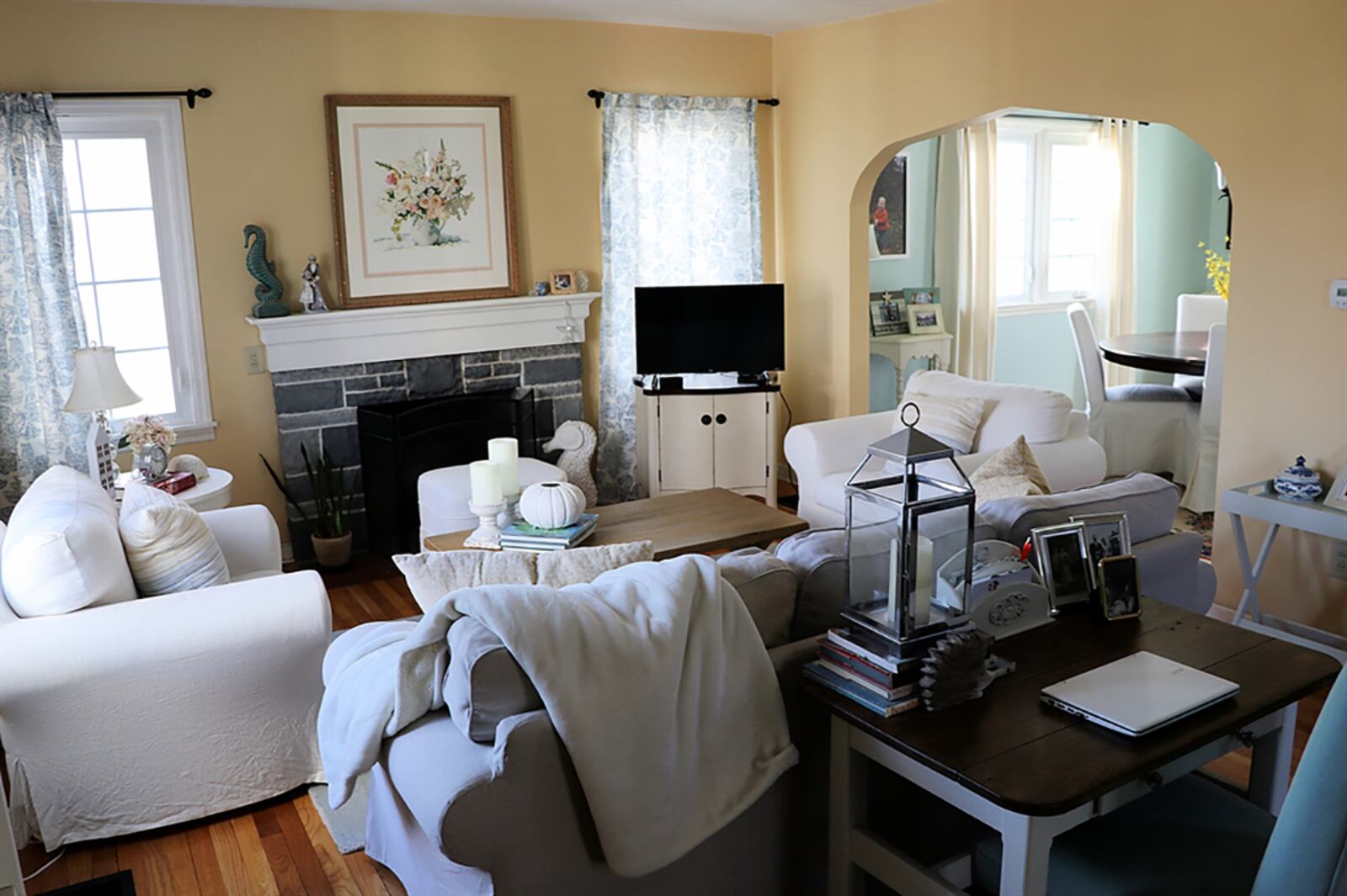 Formal entry opens off the porch into the living room with several windows that fill the room with natural light. Hardwood flooring fills the living room and continues into the adjoining dining room, which has two walls of windows. CONTRIBUTED PHOTO BY KATHY TYLER