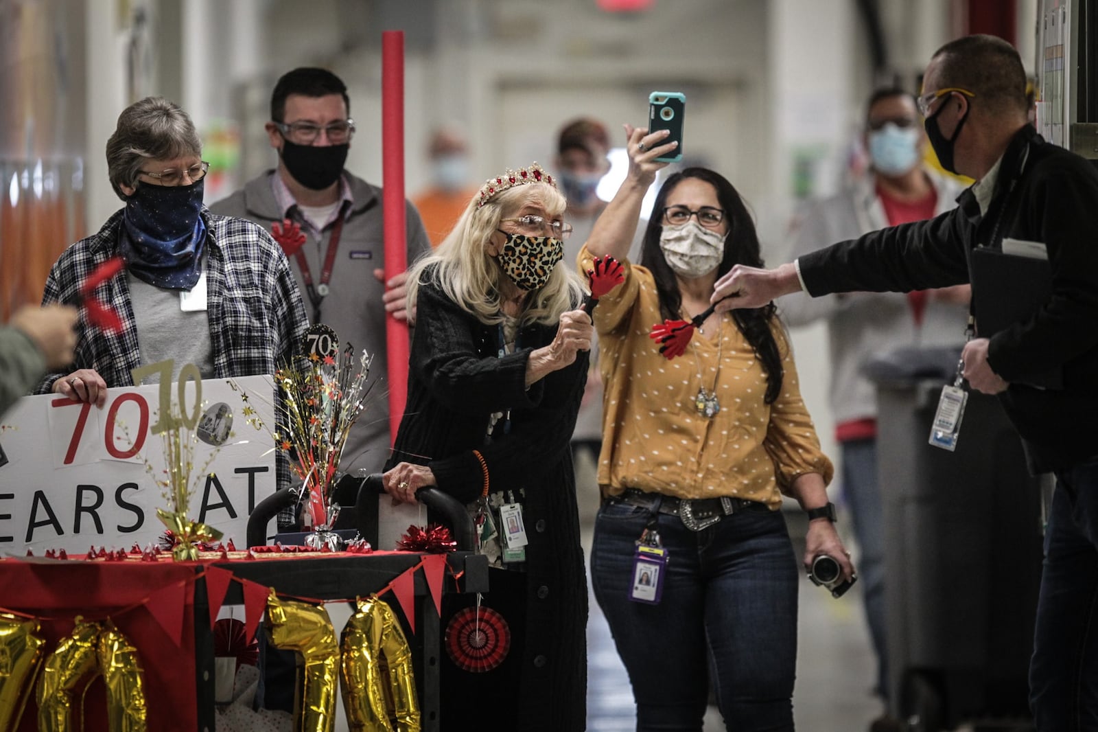 Surrounded by her coworkers, Doris Harakay, 89, parades through GE plant in Vandalia Friday morning Feb.19, 2021. Harakay has worked at the plant for 70 years and the company throw a party for her and her family. She doesn't plan to retire.