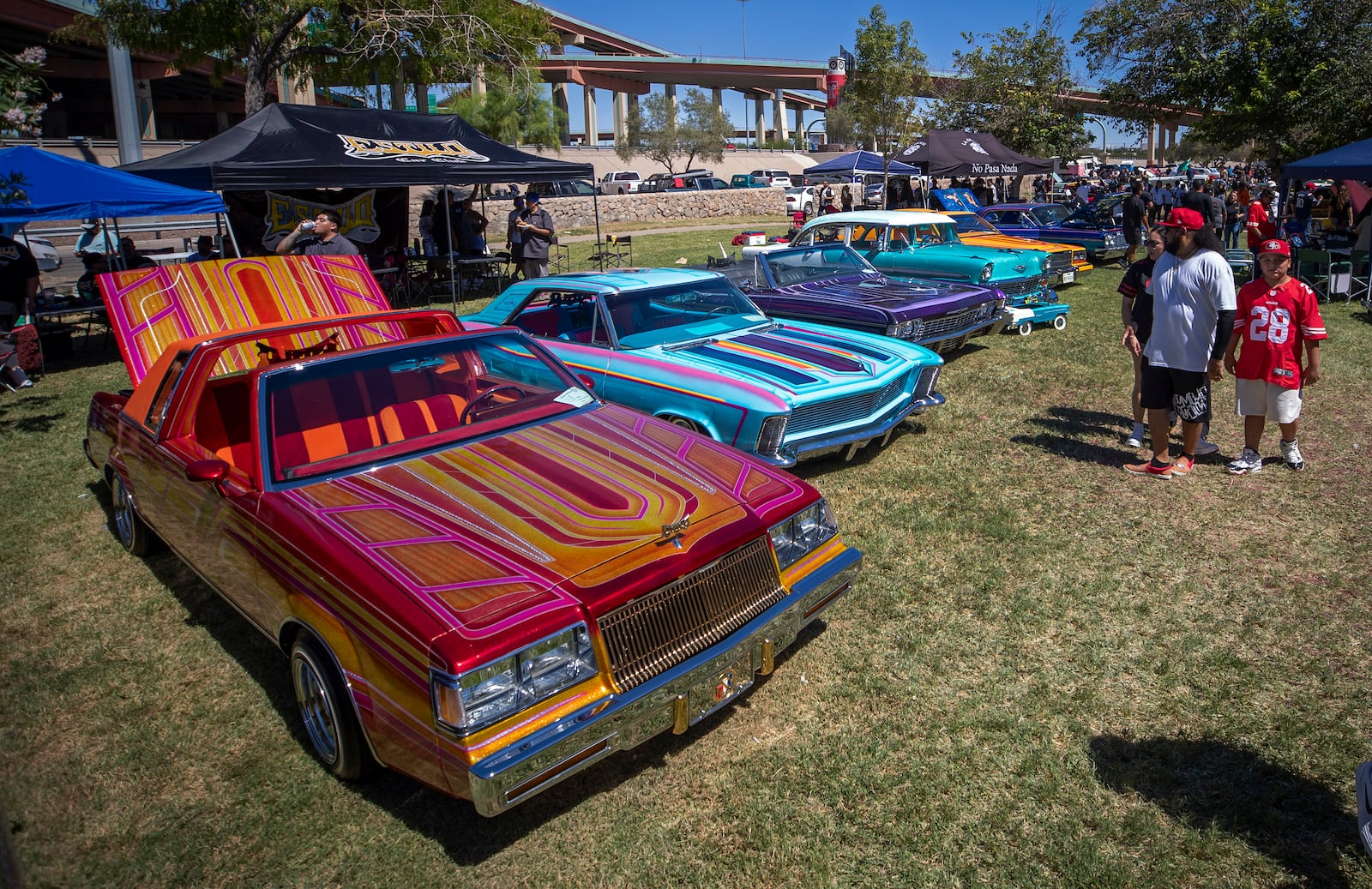 A family looks at vintage cars during a lowrider exhibition for the 20th anniversary of Lincoln Park in El Paso, Texas, Sunday, Sept. 22, 2024. (AP Photo/Andrés Leighton)