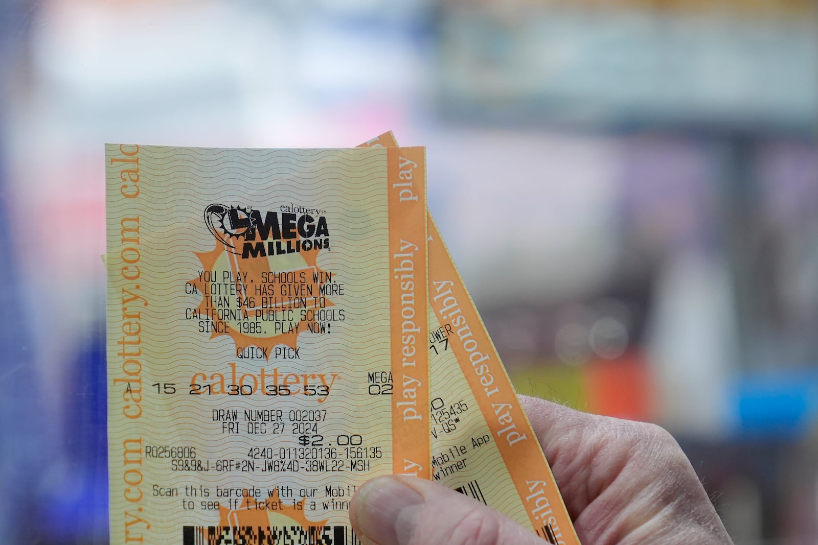 Rob holds up a Mega Millions ticket at Rossi's Deli in San Francisco, Thursday, Dec. 26, 2024. (AP Photo/Jeff Chiu)