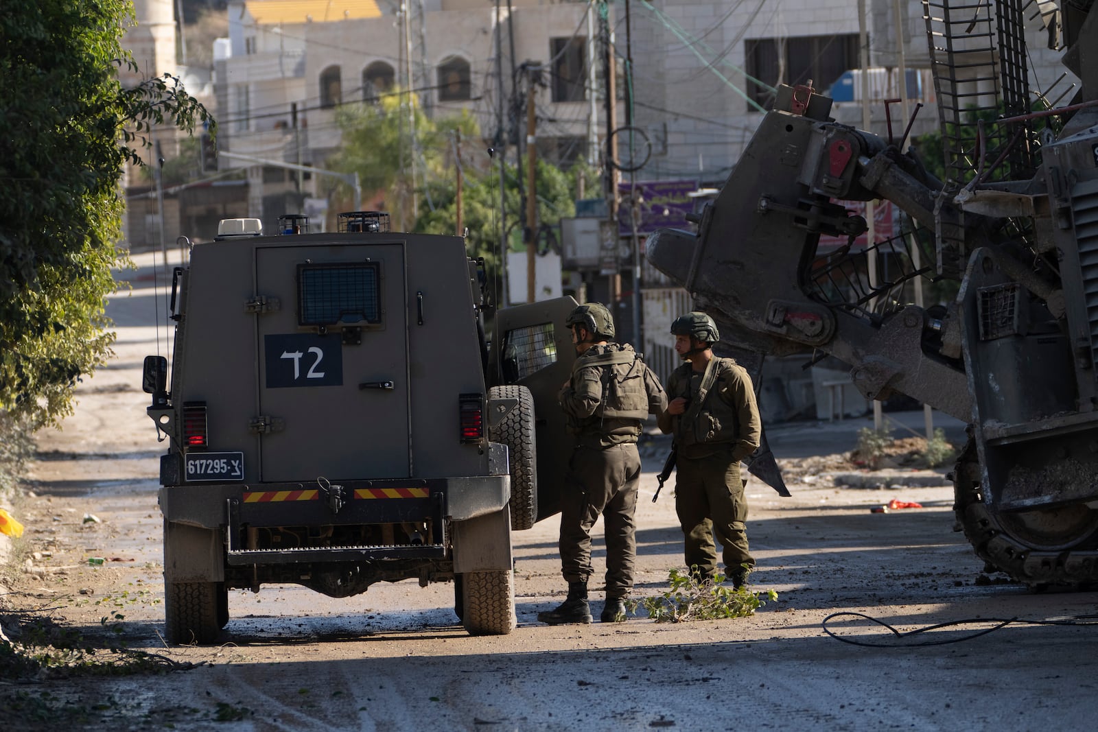 Members of Israeli forces patrol a street during a military operation in the Tulkarem refugee camp near the West Bank city of Tulkarem, Wednesday, Dec. 25, 2024. (AP Photo/Majdi Mohammed)