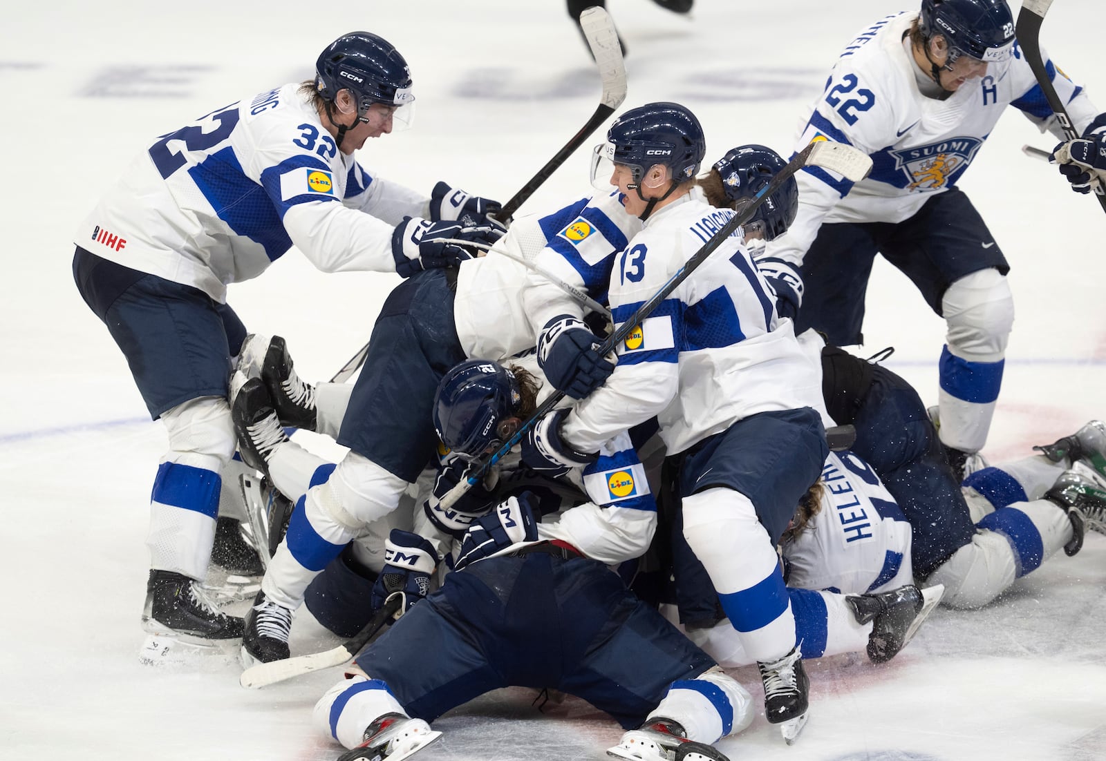 Finland players pile on teammate Benjamin Rautiainen (37) after he scored the winning goal in overtime against Sweden in semifinal game at the world junior hockey championship, Saturday, Jan. 4, 2025 in Ottawa, Ontario. (Adrian Wyld/The Canadian Press via AP)