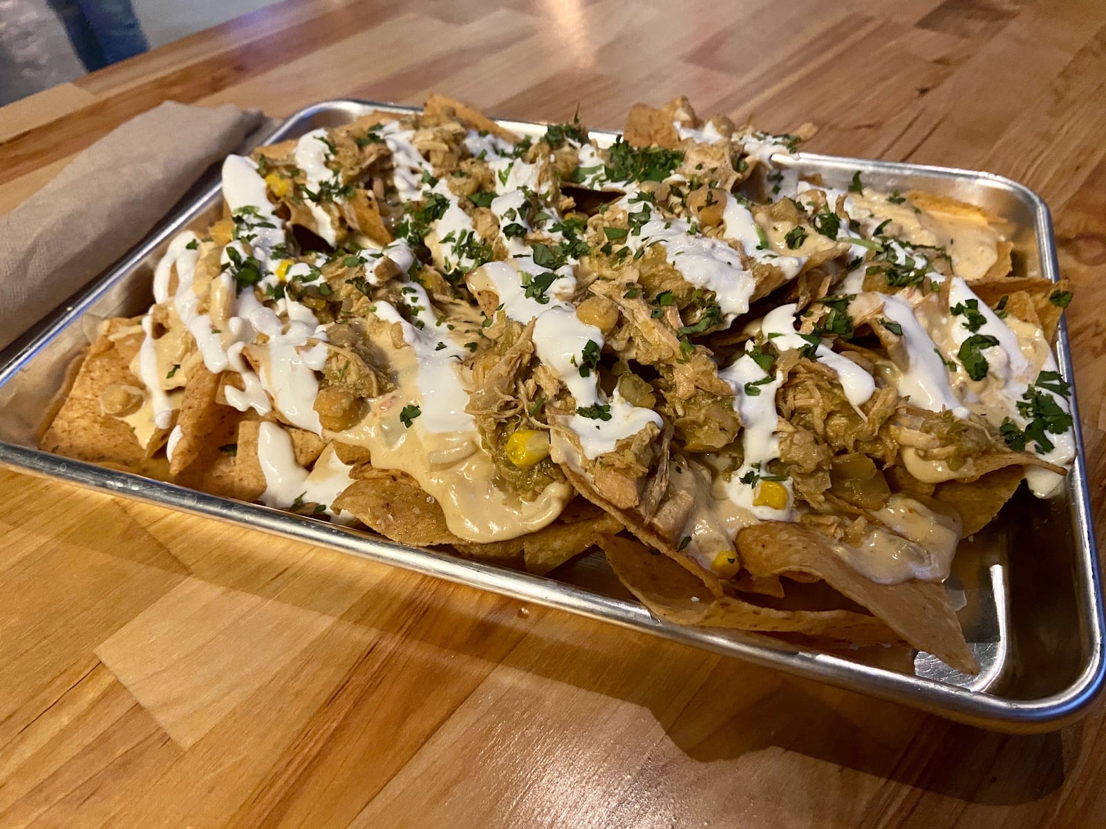 Back Home Table & Tavern's menu includes the Jump Creek Nachos, tortilla chips loaded with green chicken chili, cheese, sour cream and avocado. ALLEGRA CZERWINSKI / STAFF PHOTO