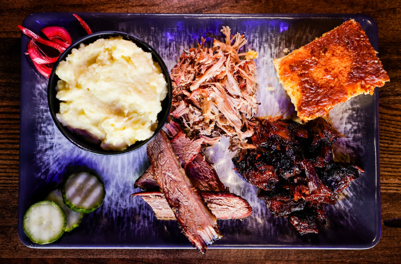 Cowboy Sally's Authentic Texas BBQ is now open at Liberty Center in Liberty Township. This plate shows a sampling of burnt ends, brisket, pulled pork, mashed potatoes and hot honey butter and pepper jack cornbread. NICK GRAHAM/STAFF