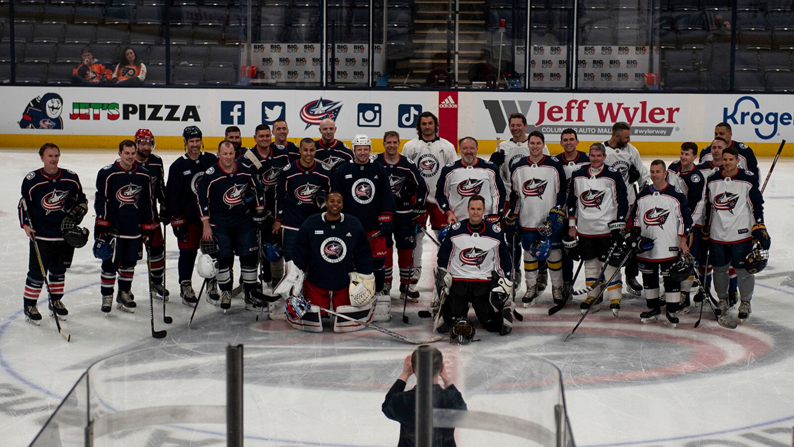 Players who competed in the alumni scrimmage take a group photo April 7 at Nationwide Arena in Columbus. Prior to facing the Philadelphia Flyers, the Columbus Blue Jackets kicked off their annual Military Appreciation Night with a friendly exhibition game featuring former players and the Wright Flyers, a recreation team made up of military and civilian personnel from Wright-Patterson Air Force Base. U.S. AIR FORCE PHOTO/SENIOR AIRMAN JACK GARDNER