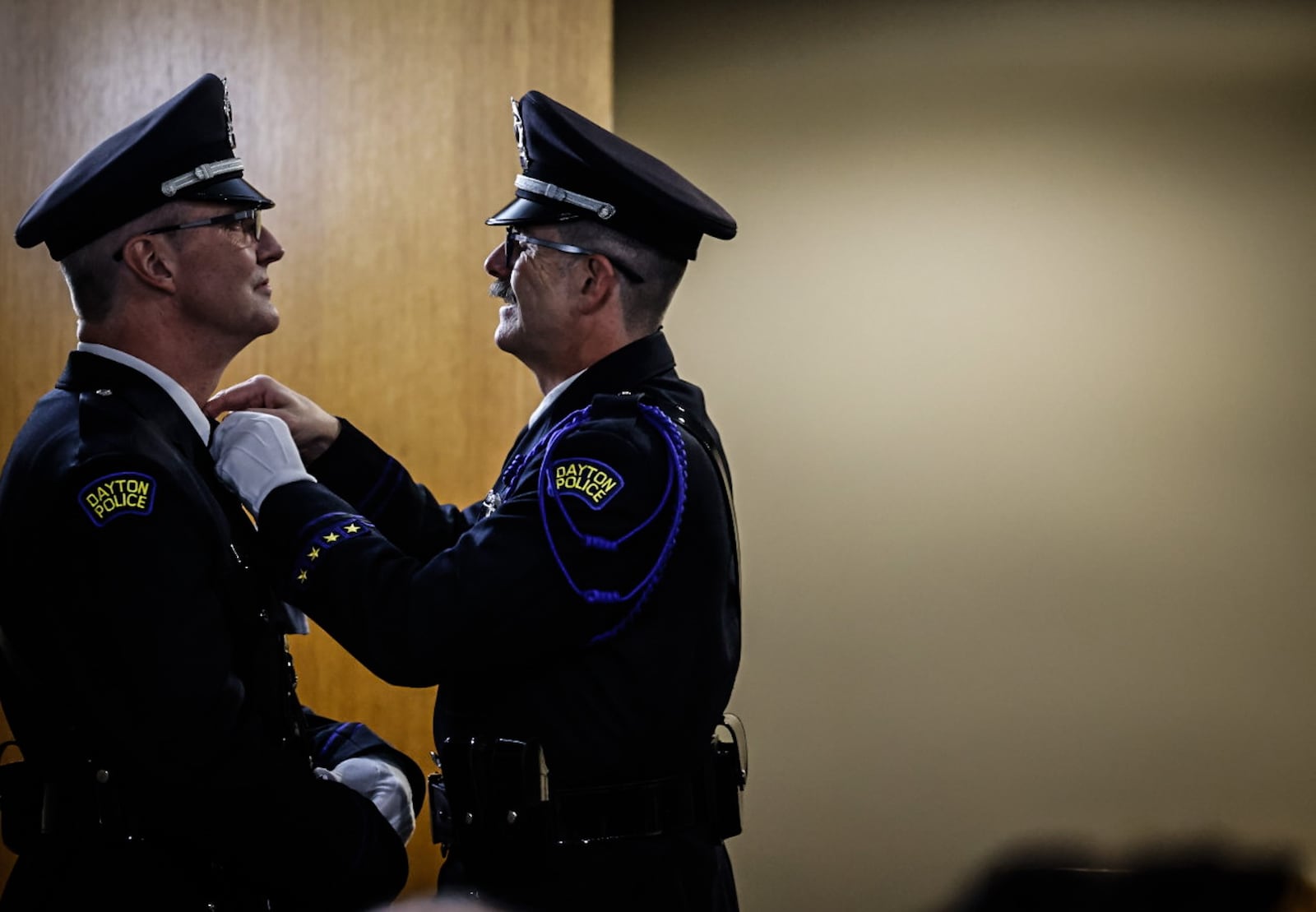 Ron Miller left and Jack Miniard get ready for the Dayton police recruit class graduation at Sinclair Collage Friday November 17, 2023. JIM NOELKER/STAFF