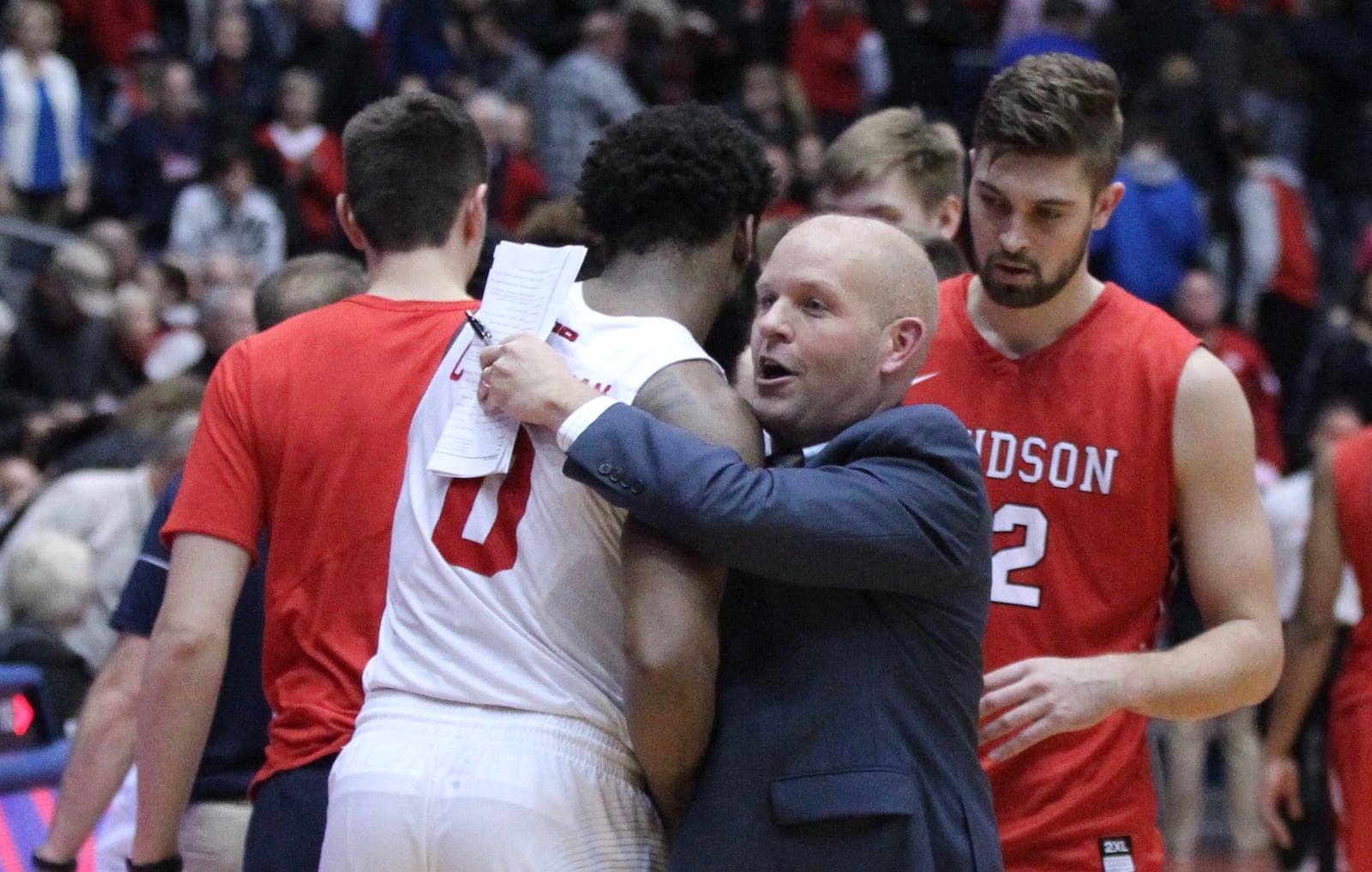 Davidson’s Kevin Kuwik hugs Dayton’s Josh Cunningham after a game on Tuesday, Jan. 23, 2018, at UD Arena. David Jablonski/Staff