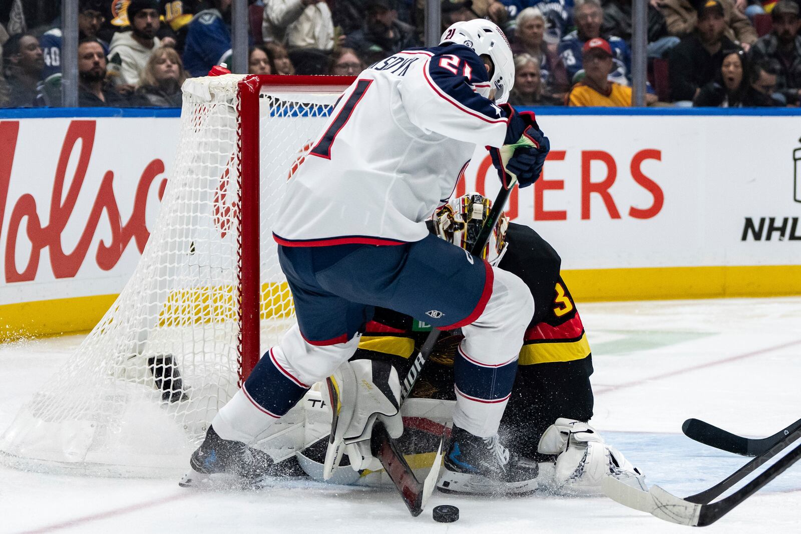 Vancouver Canucks goaltender Kevin Lankinen (32) stops Columbus Blue Jackets' James van Riemsdyk (21) during the second period of an NHL hockey game in Vancouver, British Columbia, Friday, Dec. 6, 2024. (Ethan Cairns/The Canadian Press via AP)