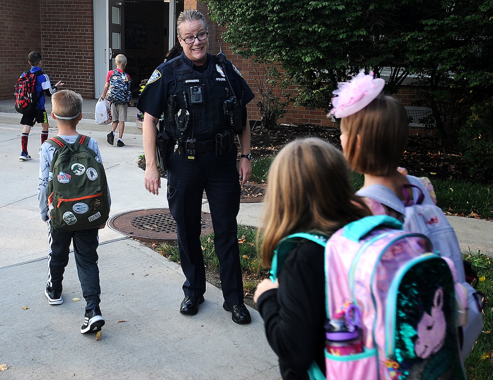 Centerville Police officer Tracy Sommers greets students as they arrive at Cline Elementary in Centerville for the first day of school Wednesday, Aug. 16, 2023 . MARSHALL GORBY\STAFF