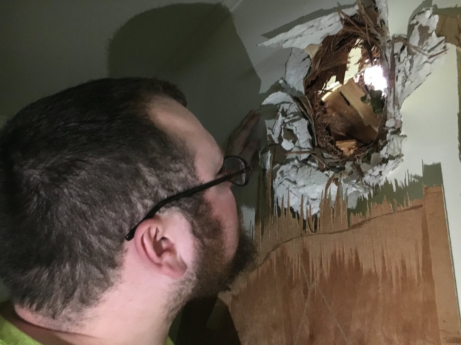 Michael Santana assesses damage to his home at the Overlook Houses in Riverside after a Memorial Day tornado threw a tree limb through his walls. STAFF PHOTO / HOLLY SHIVELY