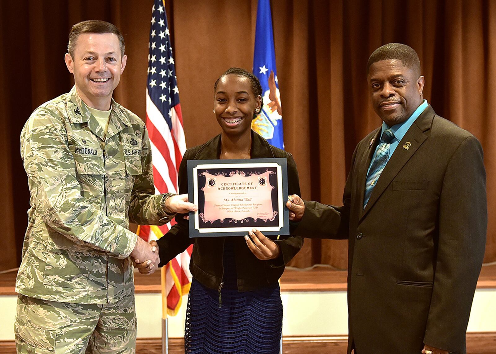 Col. Bradley McDonald (left), 88th Air Base Wing commander, and Terrance Williams (right), president of the local Greater Daytonl Blacks in Government chapter, present the annual Black History Month Scholarship to Alanna Wall, a senior at Stivers High School for the Arts, in a ceremony at Wright-Patterson Air Force Base, Feb. 21. Black History Month is an annual celebration of achievements by African Americans and a time for recognizing the central role of blacks in U.S. history. (U.S. Air Force photo/Al Bright)