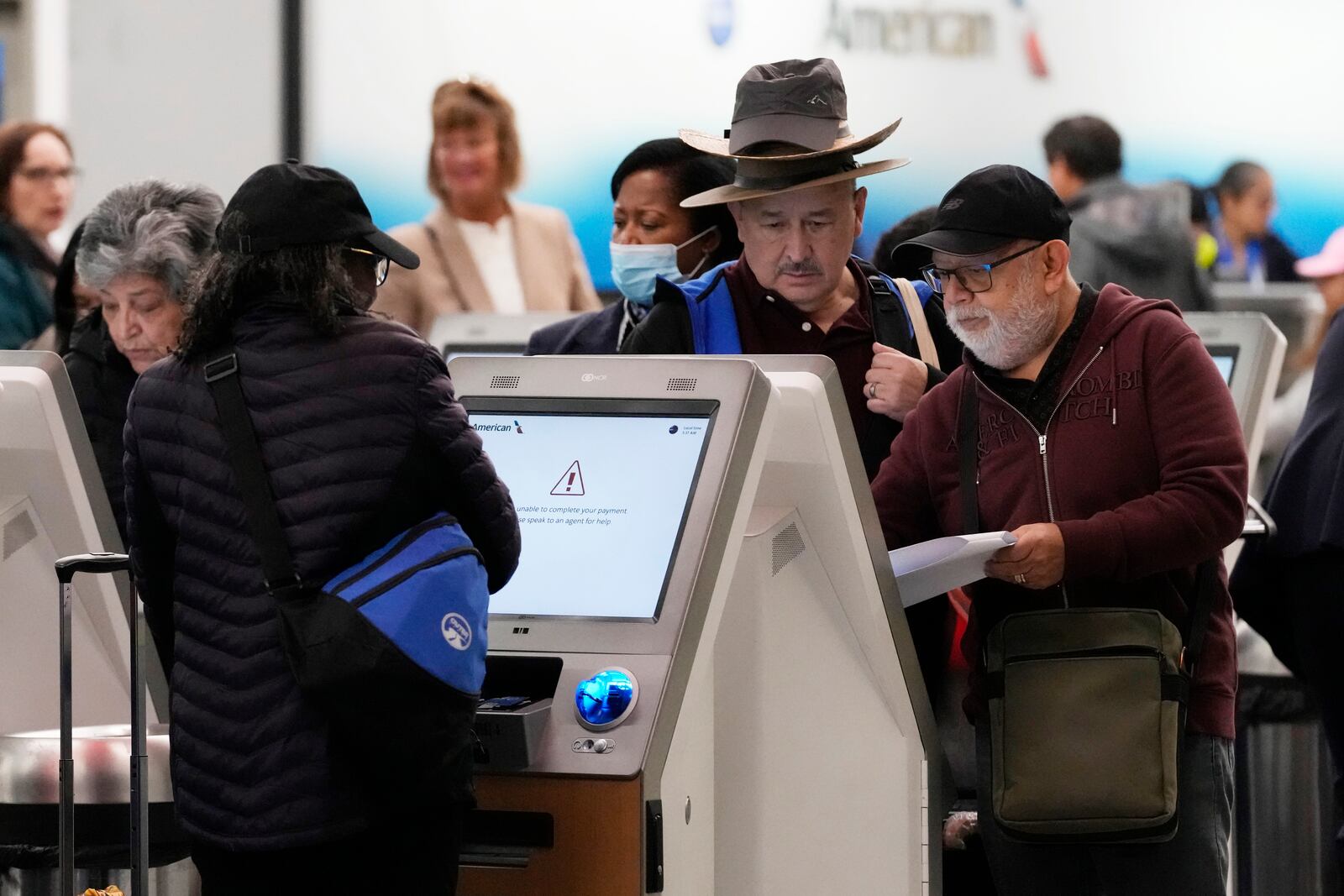 Travelers check their tickets at O'Hare International Airport in Chicago, Tuesday, Nov. 26, 2024. (AP Photo/Nam Y. Huh)