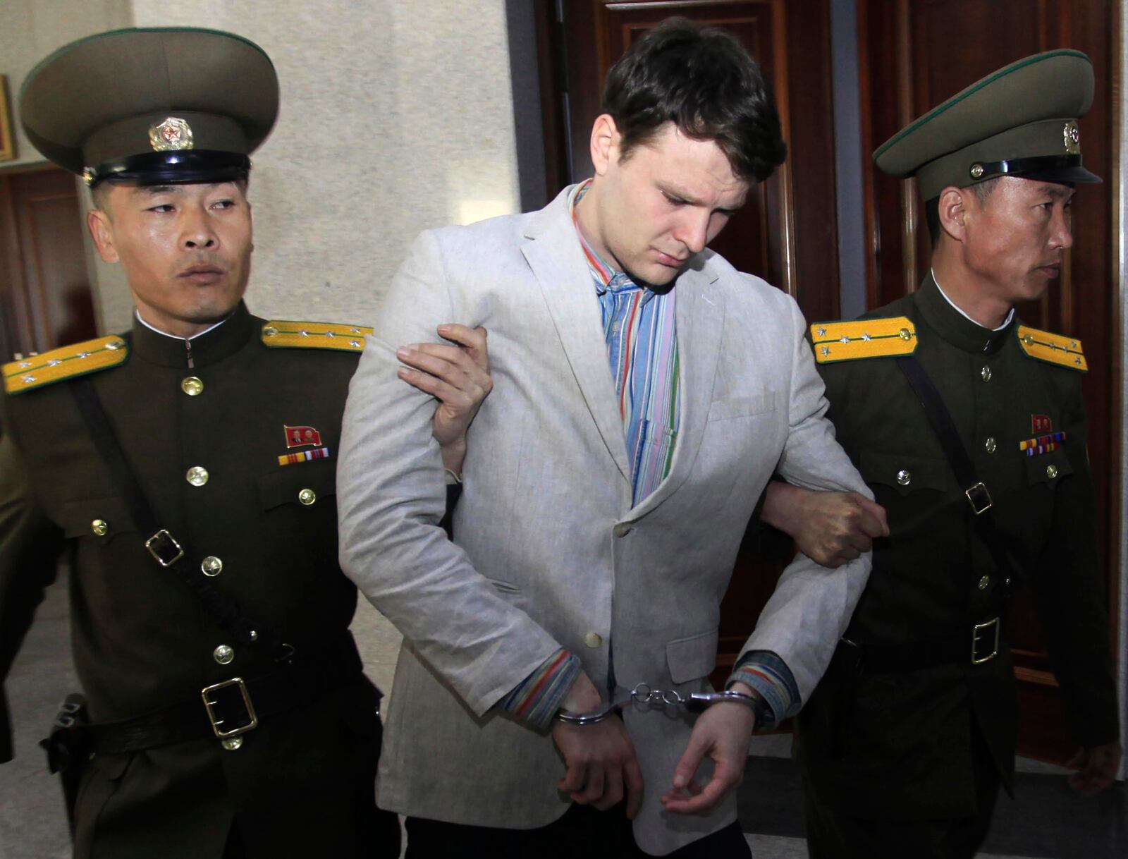 FILE - American student Otto Warmbier, center, is escorted at the Supreme Court in Pyongyang, North Korea, March 16, 2016. (AP Photo/Jon Chol Jin, File)