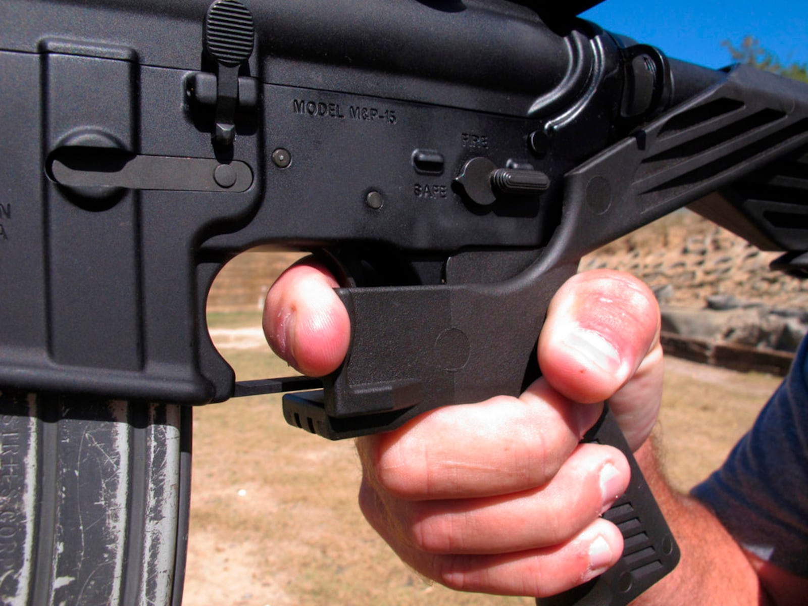 FILE - In this Oct. 4, 2017, file photo, shooting instructor Frankie McRae demonstrates the grip on an AR-15 rifle fitted with a "bump stock" at his 37 PSR Gun Club in Bunnlevel, N.C. The largest manufacturer of bump stocks, which allow semi-automatic weapons to fire rapidly like automatic firearms, announced Wednesday, April 18, 2018, that it will stop taking orders and shut down its website next month. (AP Photo/Allen G. Breed, File)