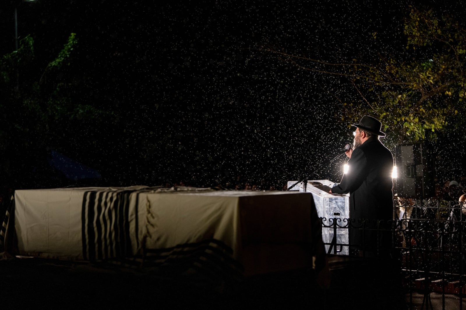 A rabbi delivers an eulogy next to the coffin containing the remains of Israeli-Moldovan rabbi Zvi Kogan in Kfar Chabad, Israel, Monday Nov. 25, 2024. Kogan, 28, an ultra-Orthodox rabbi, was killed last week in Dubai where he ran a kosher grocery store. Israelis have flocked for commerce and tourism since the two countries forged diplomatic ties in the 2020 Abraham Accords.(AP Photo/Ohad Zwigenberg)