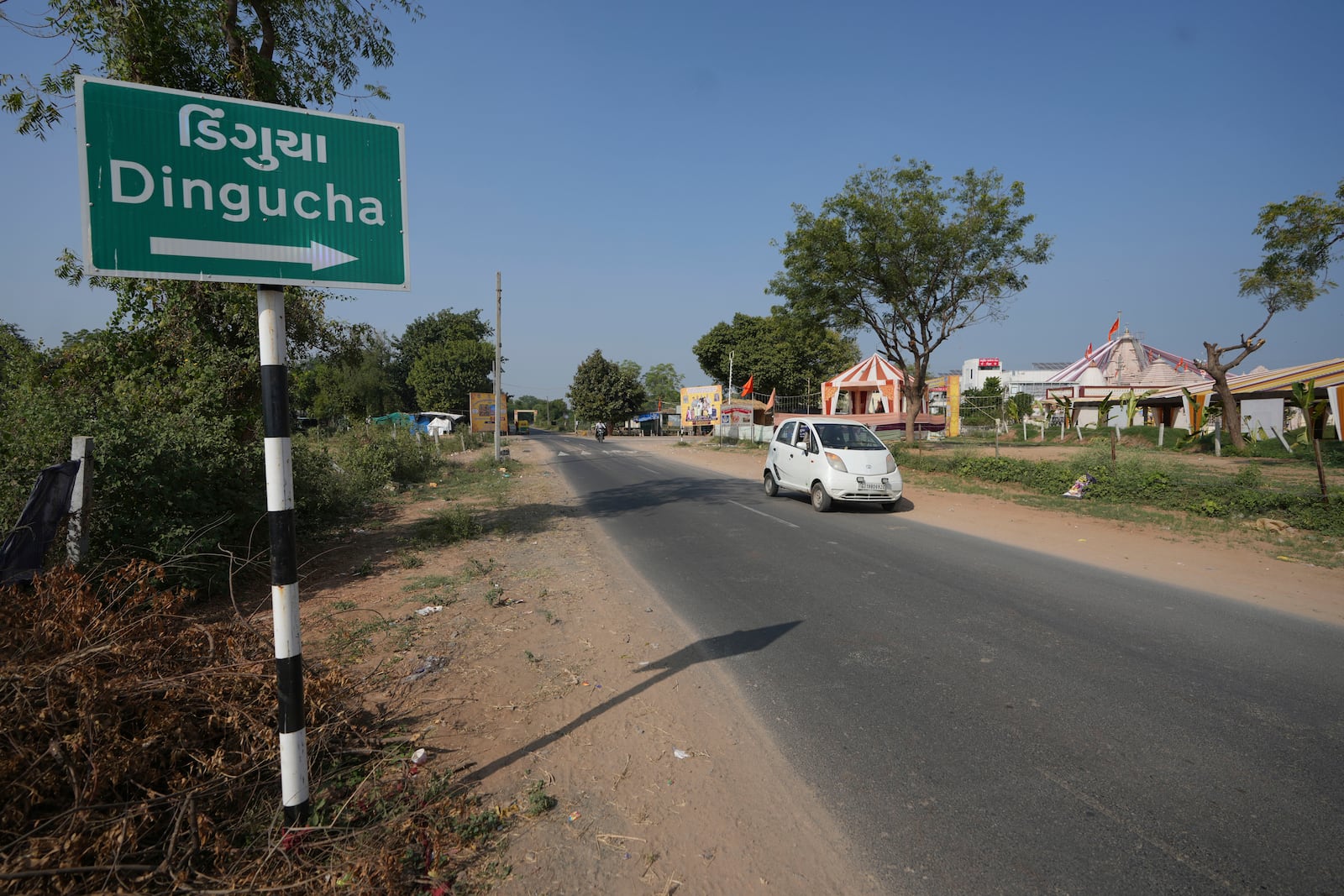 A car moves past a signage of Dingucha village in Gandhinagar, India, Tuesday, Nov. 12, 2024. (AP Photo/Ajit Solanki)