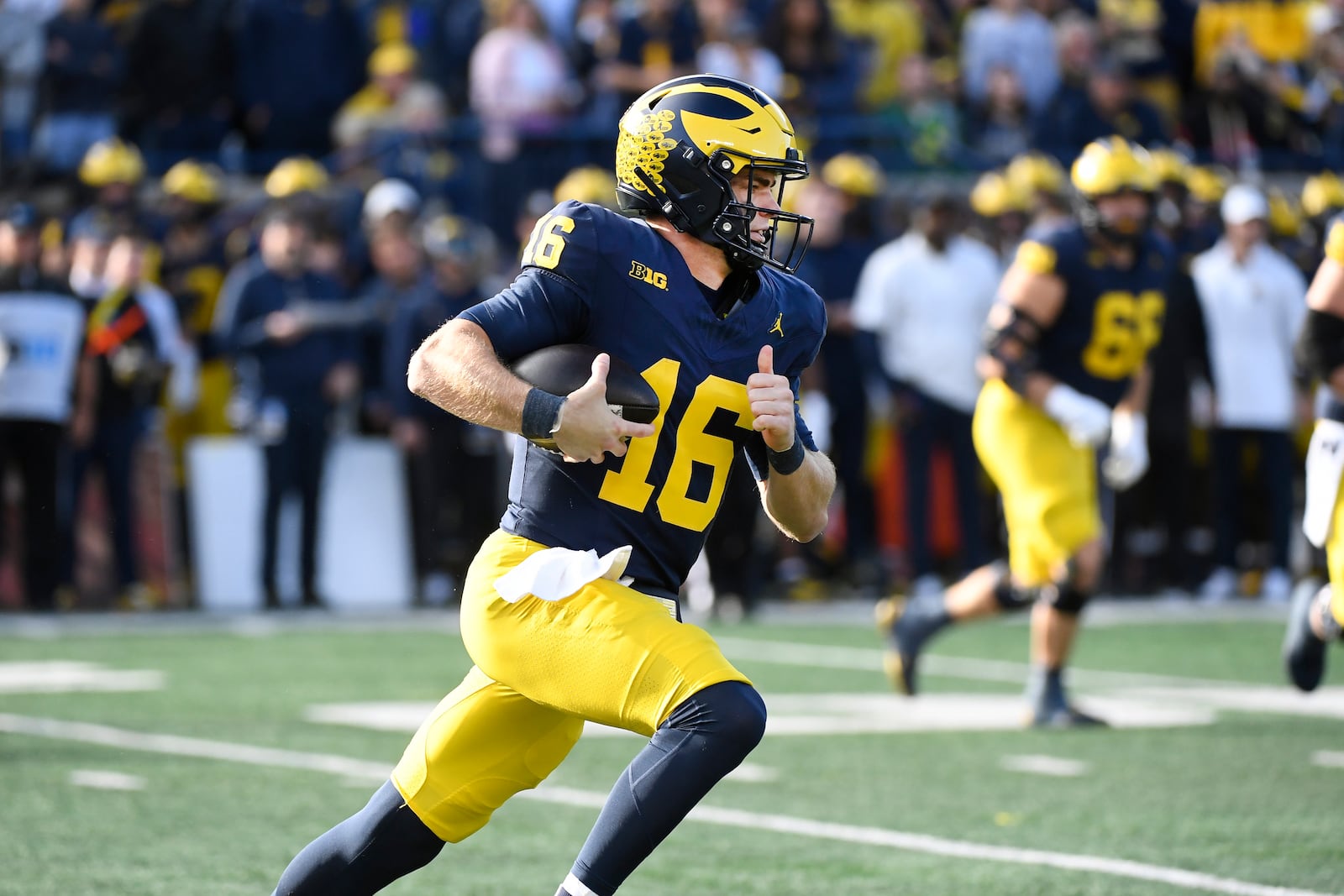 Michigan quarterback Davis Warren scrambles out of the pocket against Oregon during the first half of an NCAA college football game, Saturday, Nov. 2, 2024, in Ann Arbor, Mich. (AP Photo/Jose Juarez)