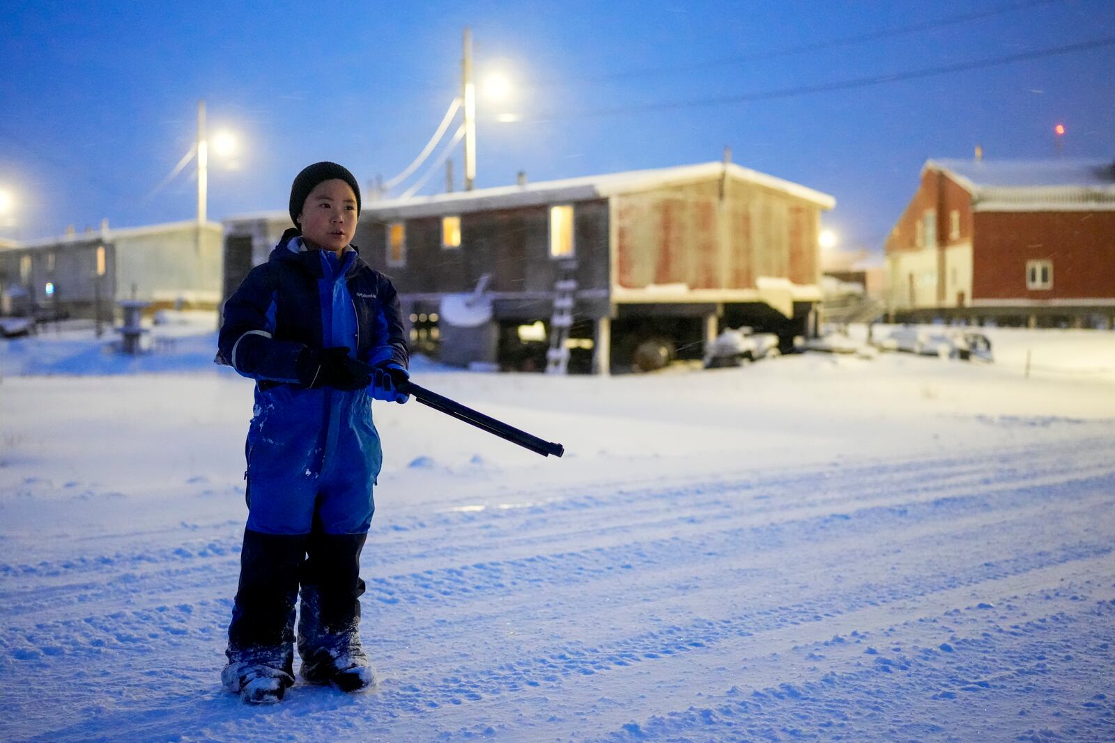 Johnny, 7, holds his pellet gun for warding away polar bears as he goes out to play with other children after school in Kaktovik, Alaska, Wednesday, Oct. 16, 2024. (AP Photo/Lindsey Wasson)