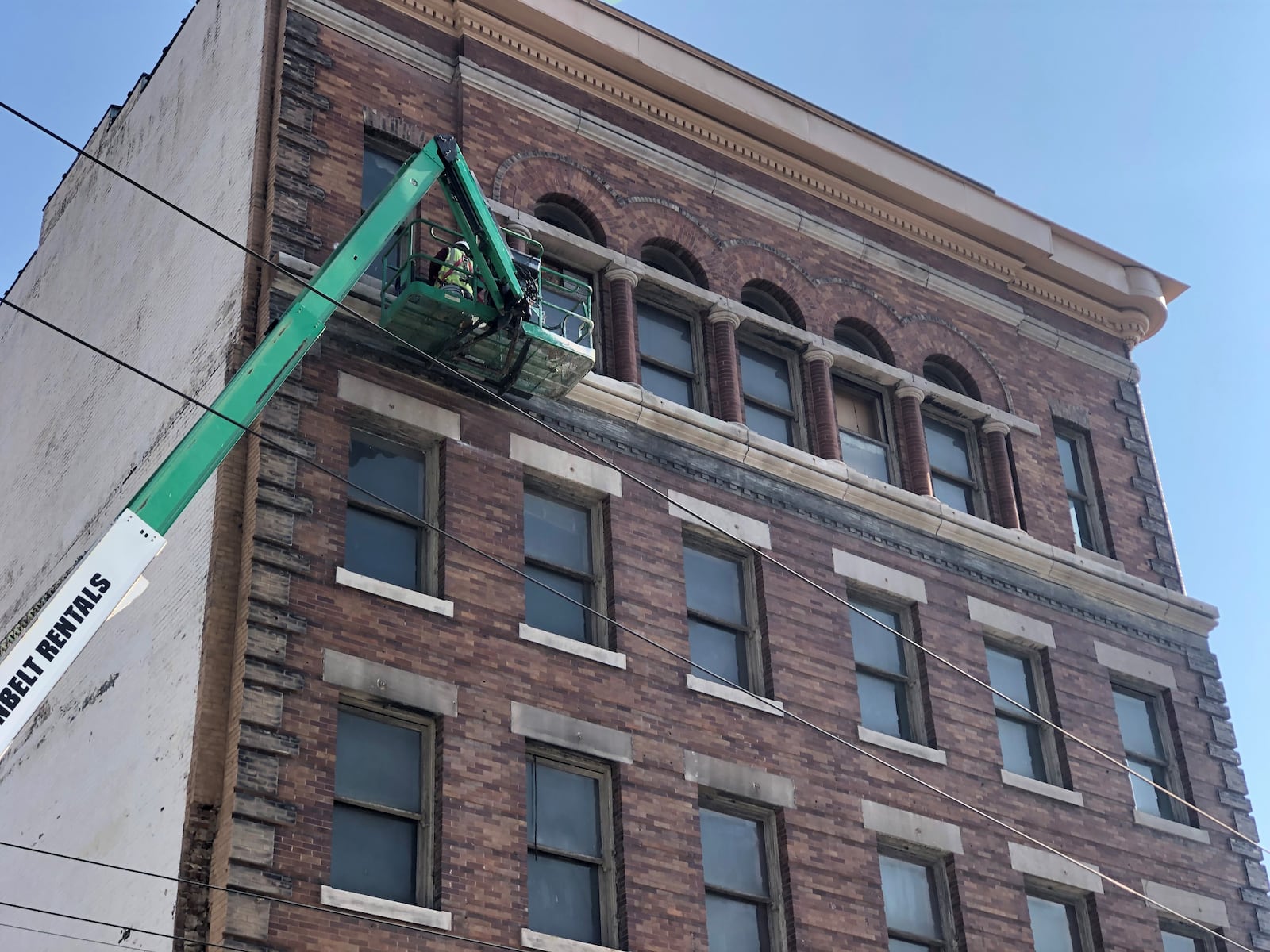 A construction worker works on the outside of the Price Stores building at South Jefferson and East Fourth streets. CORNELIUS FROLIK / STAFF